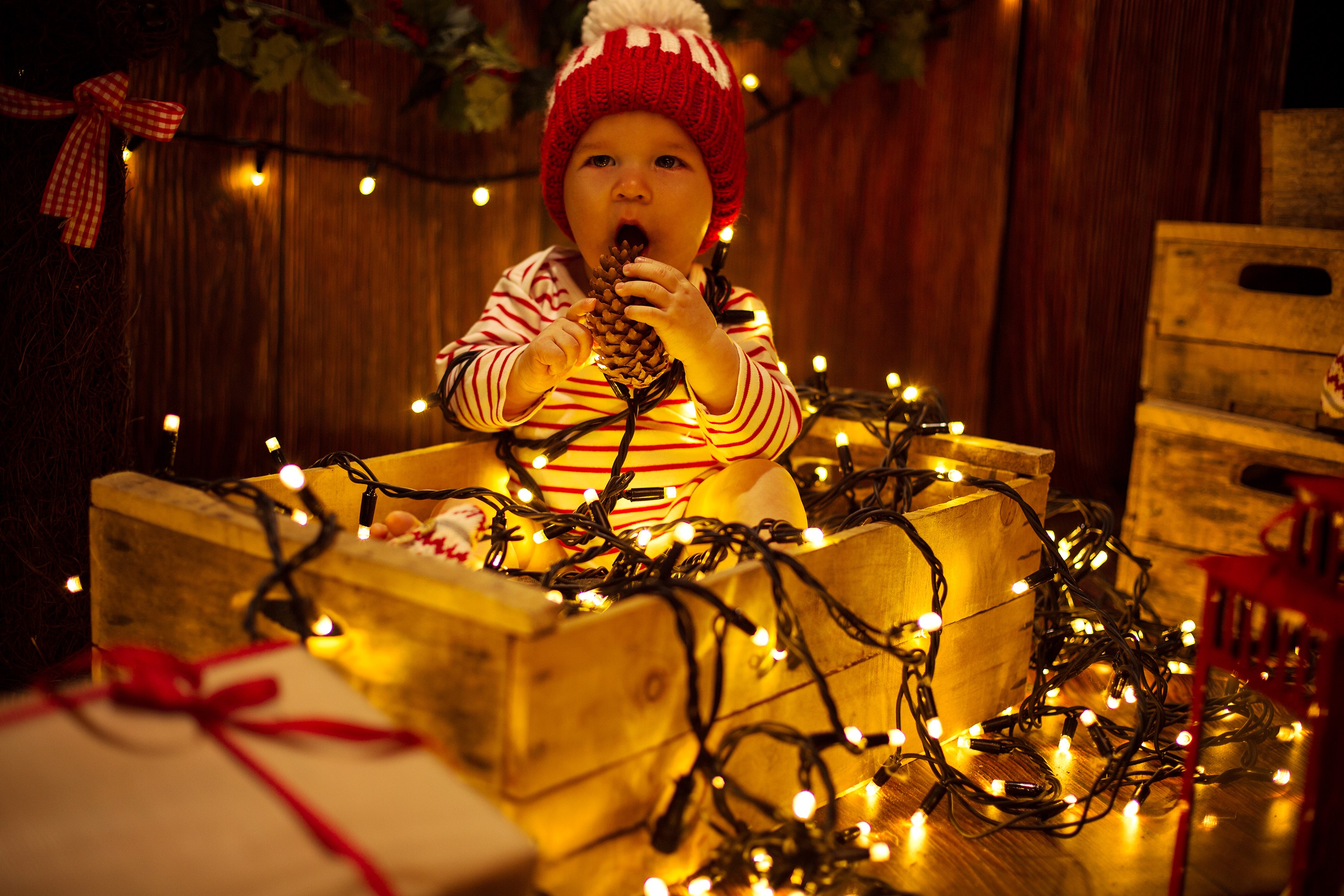 Baby in a wooden crate with Christmas lights HD Wallpaper