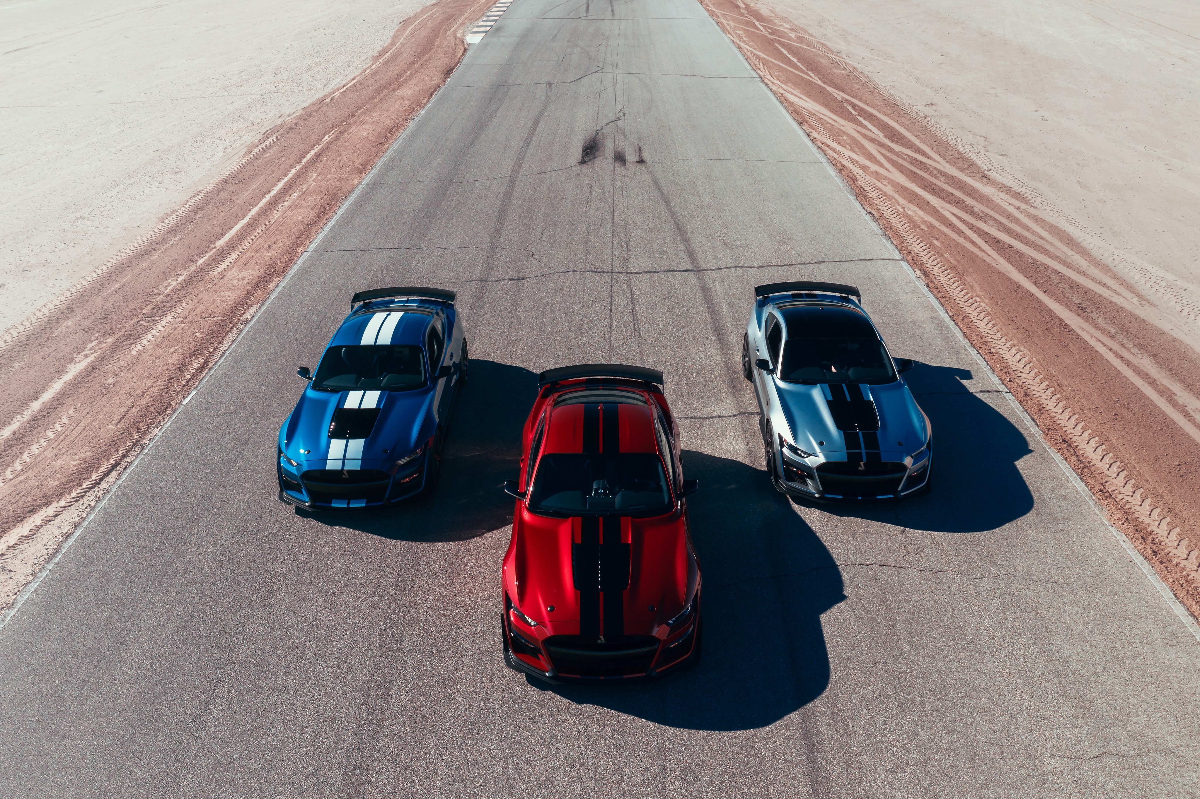Three Ford Mustang Shelby GT500 cars on a racetrack HD Wallpaper