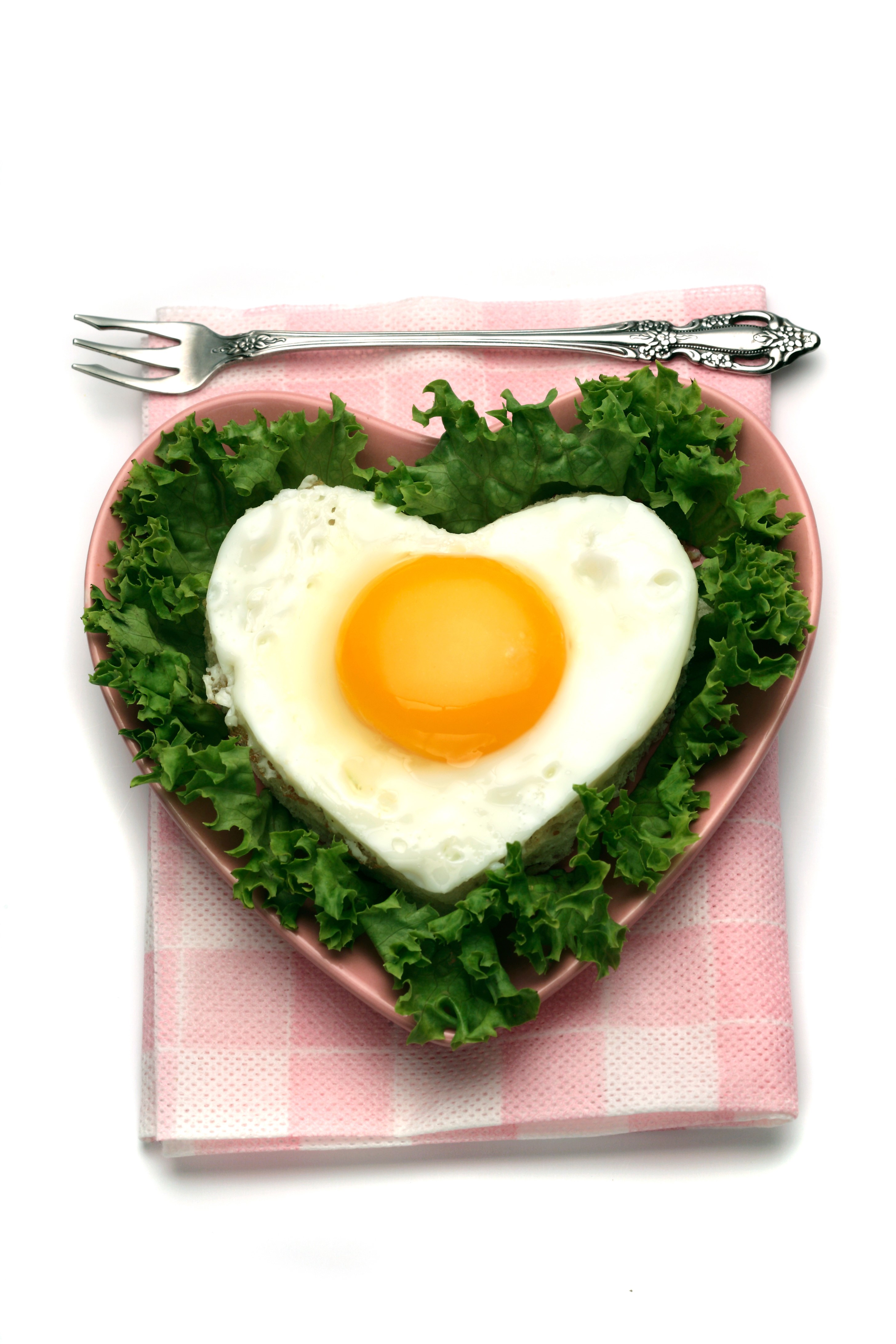 Heart-shaped fried egg on lettuce with fork HD Phone Wallpaper