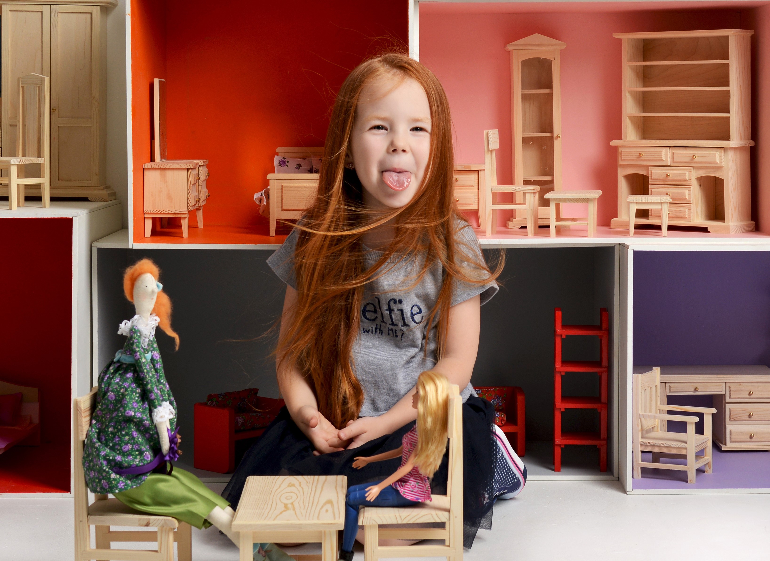 Redhead girl sticking her tongue out in a dollhouse HD Wallpaper