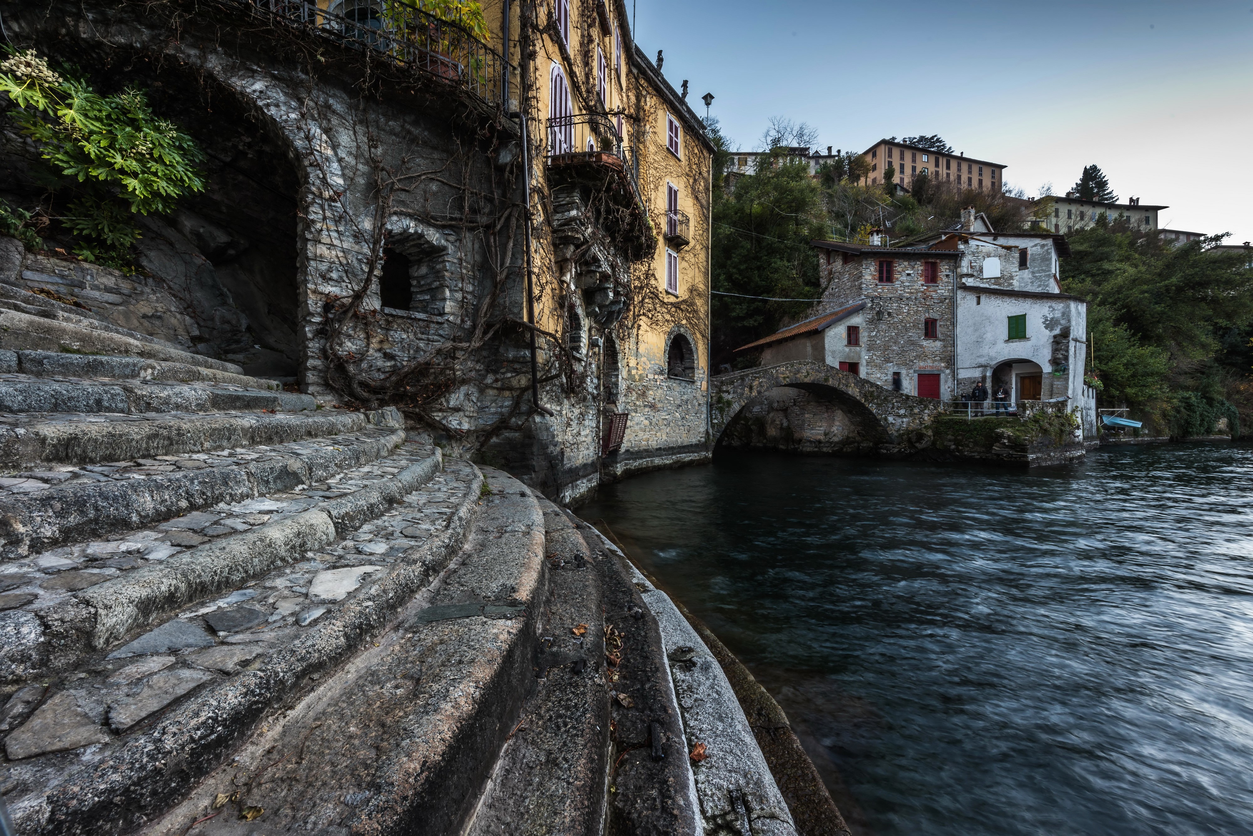 Stone stairs and buildings by a river in Nesso, Italy HD Wallpaper