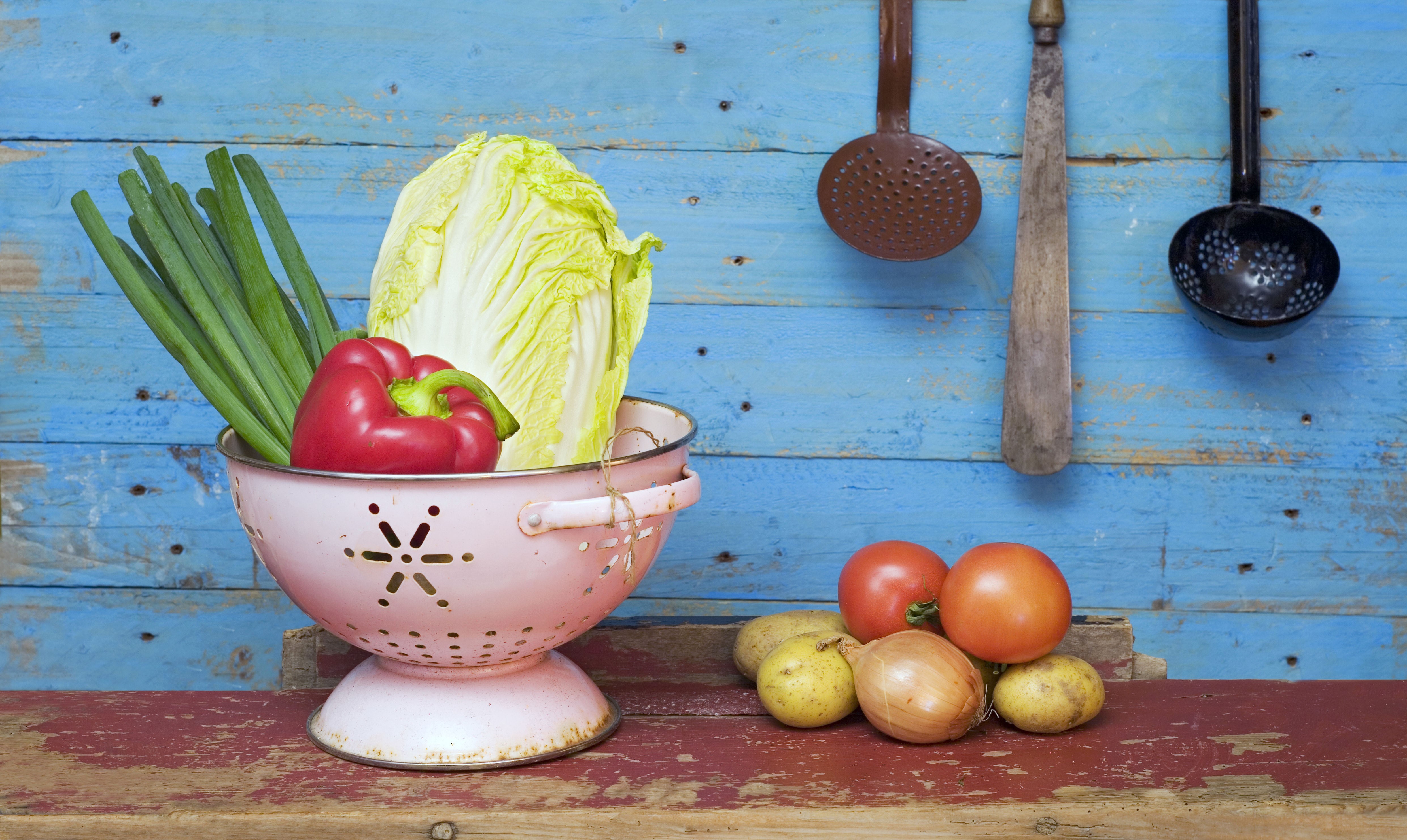 Vegetables in a colander on wooden planks HD Wallpaper