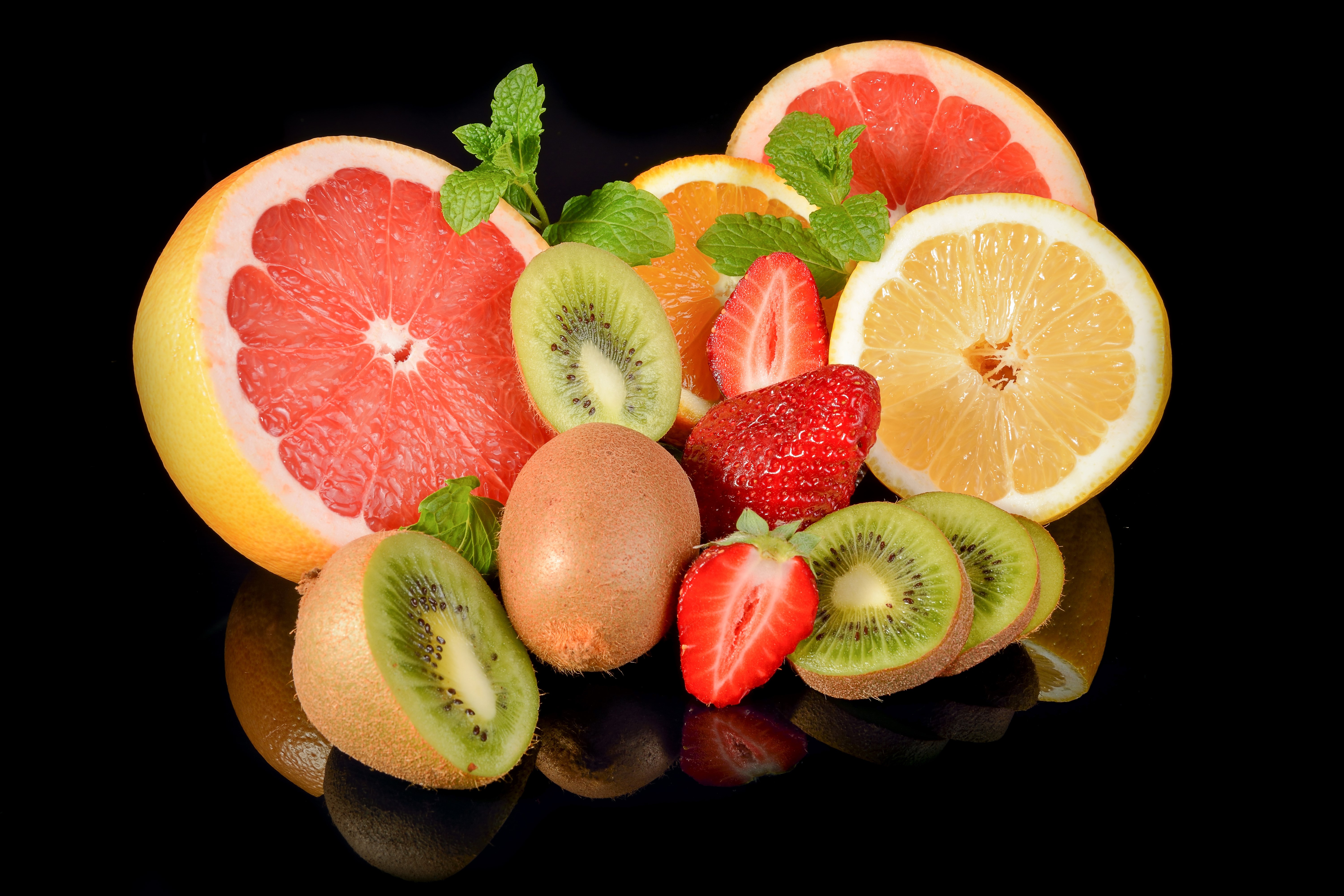 Grapefruit, Kiwi, Strawberry, Orange, Lemon slices with mint on black background HD Wallpaper