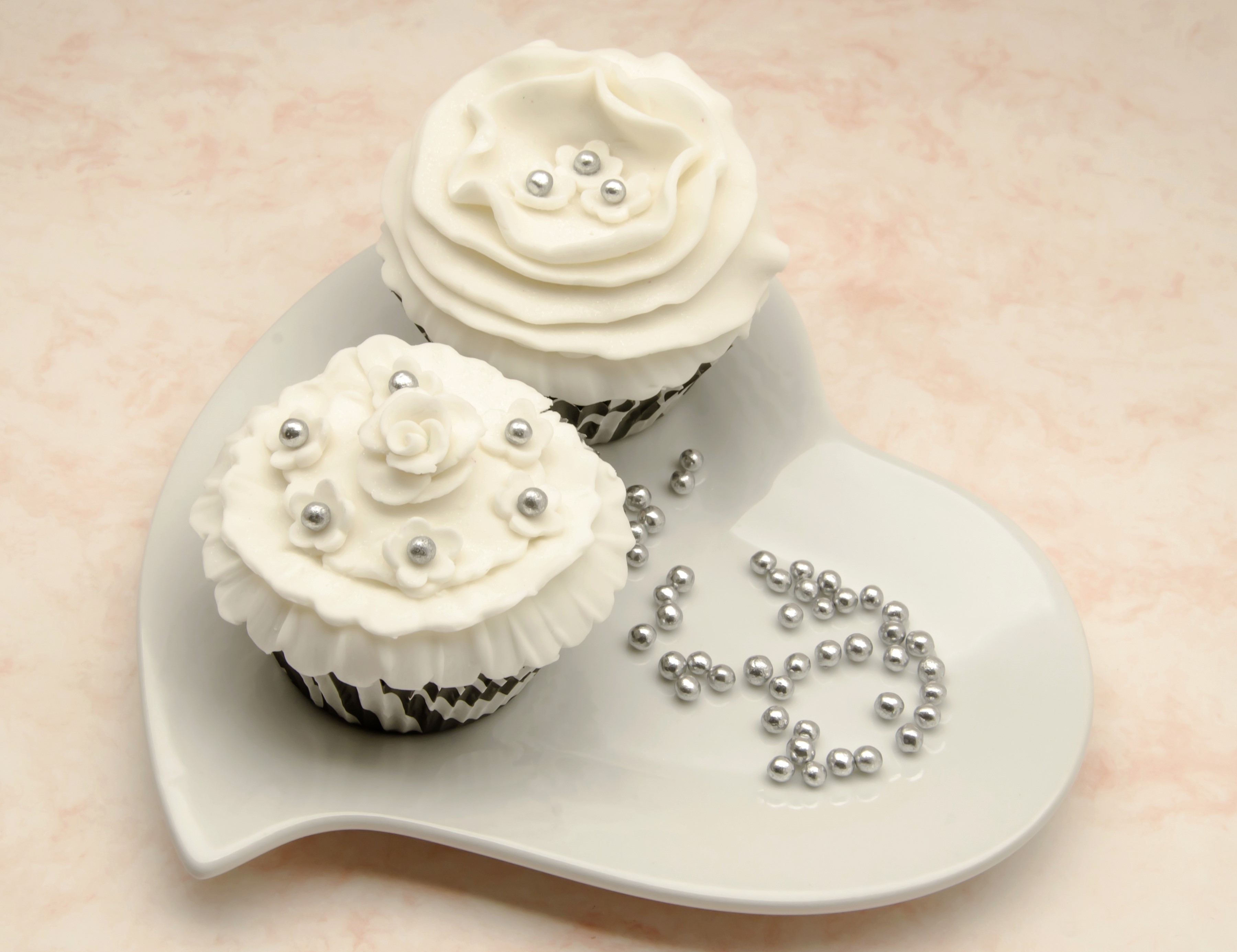 Two white cupcakes with silver decorations on a heart-shaped plate HD Wallpaper