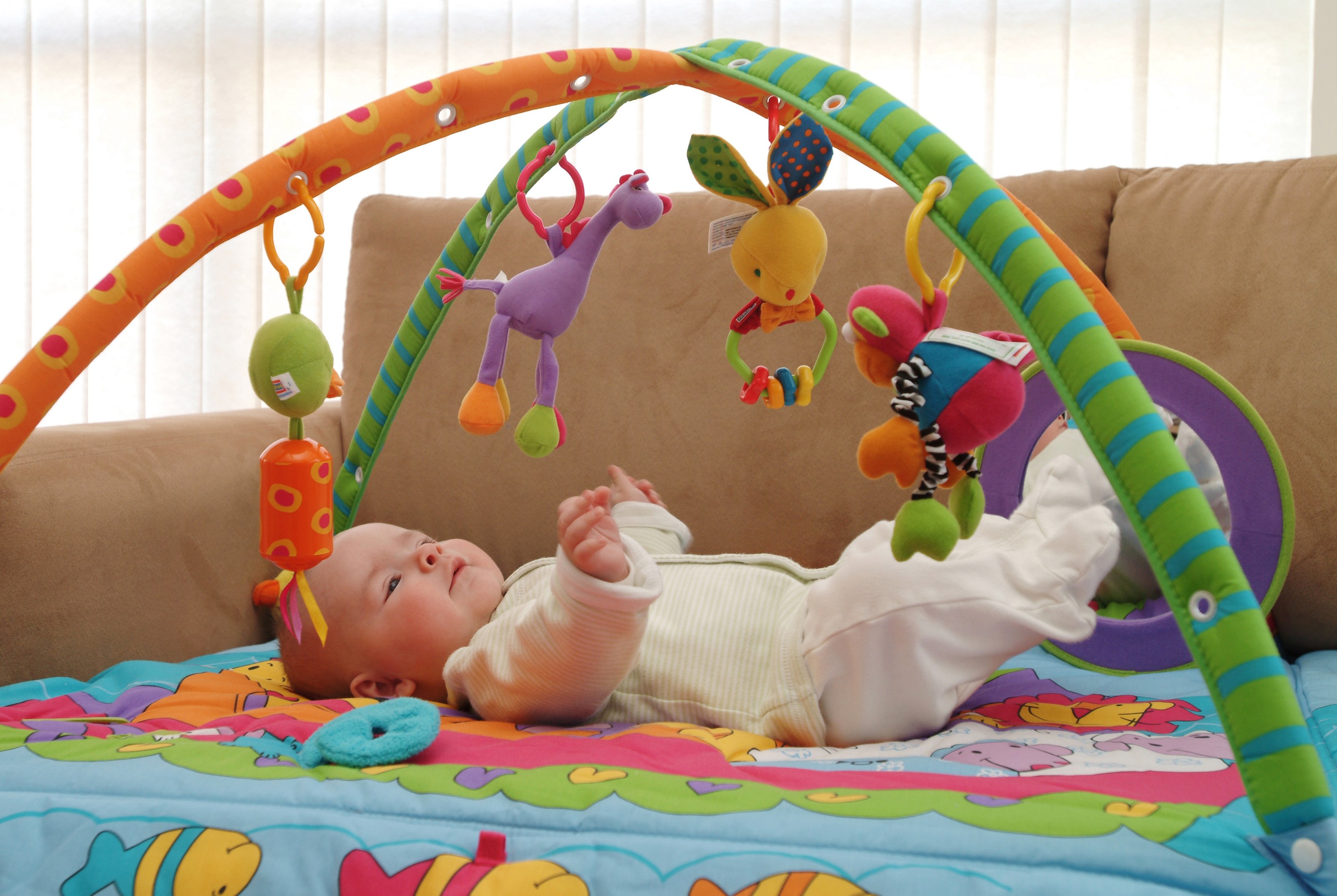 Baby playing with a colorful activity gym HD Wallpaper