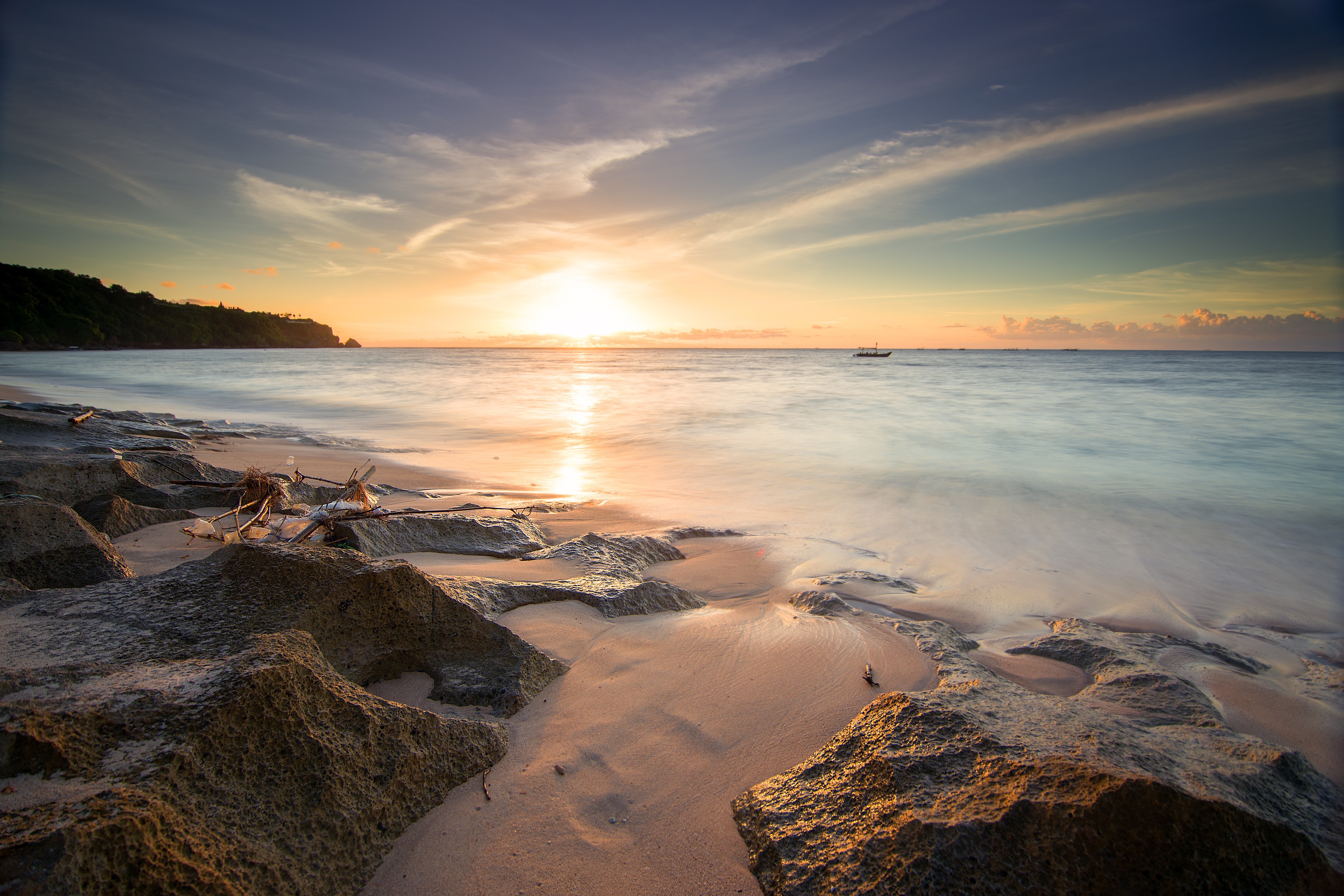 Sunset over the ocean with rocks on the shore HD Wallpaper