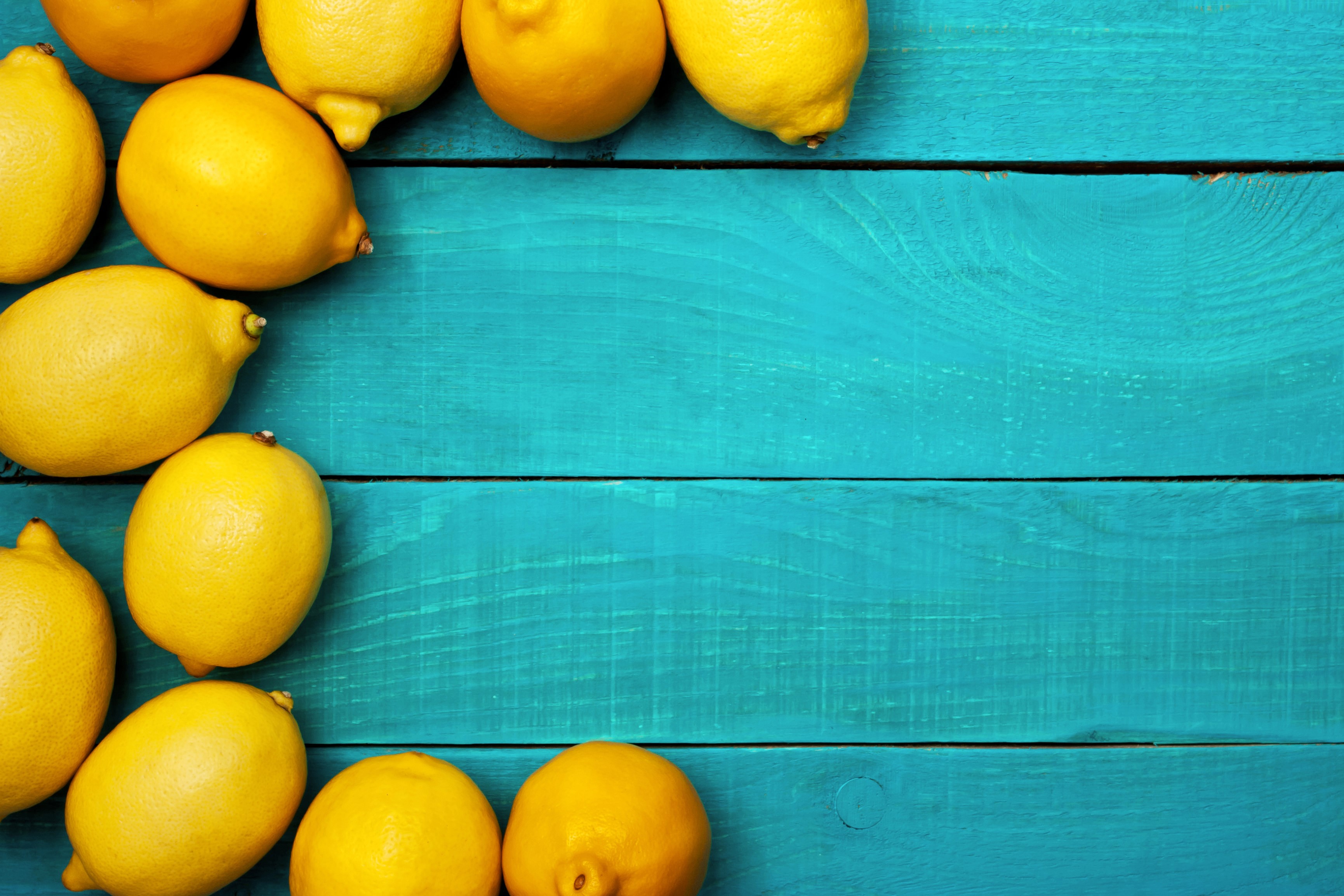 Lemons on a teal wooden surface HD Wallpaper