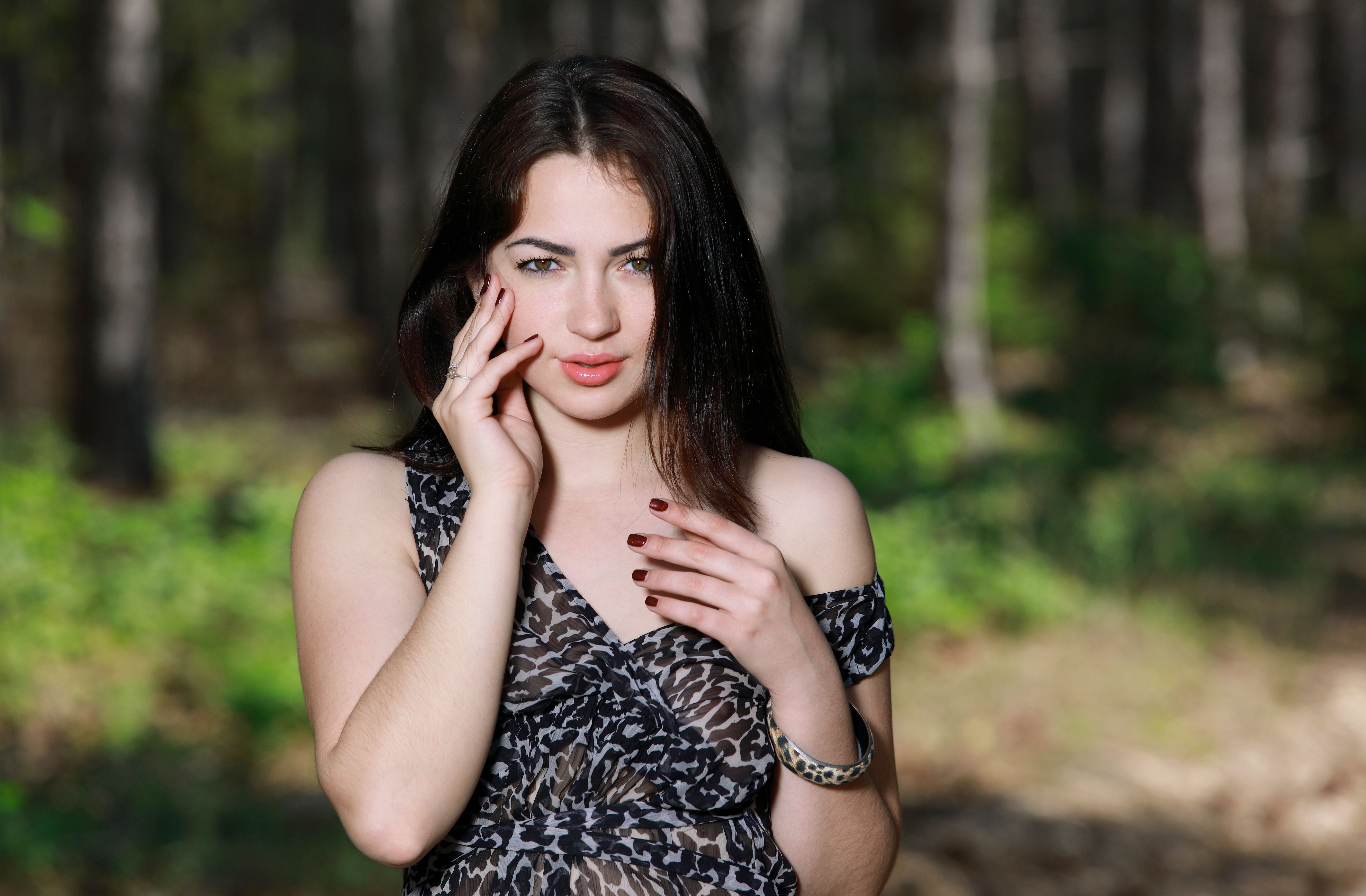 Brunette girl with hands near face in forest HD Wallpaper