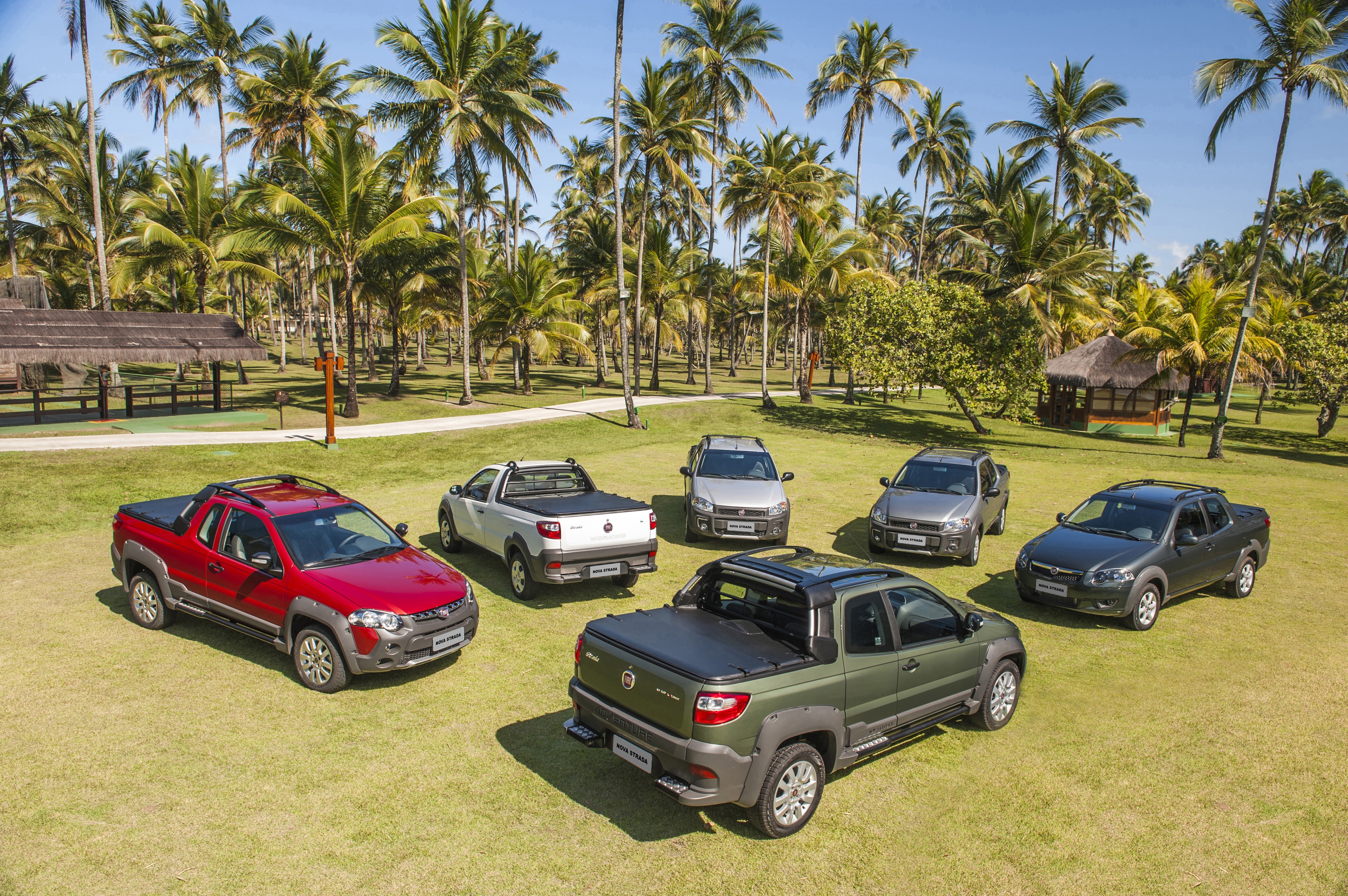 Fiat Strada pickup trucks on a lawn with palm trees HD Wallpaper