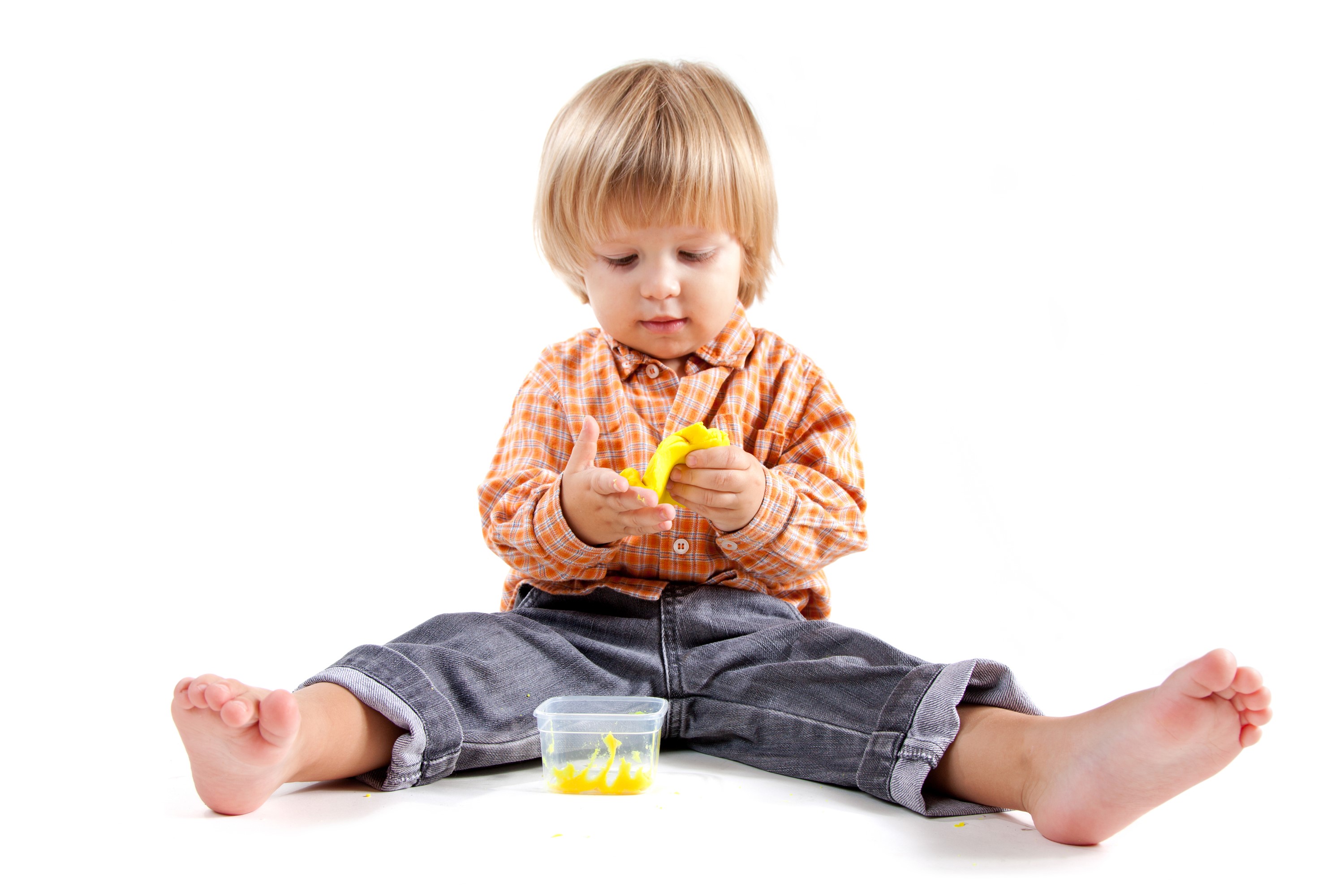 Boy playing with yellow clay on white background HD Wallpaper