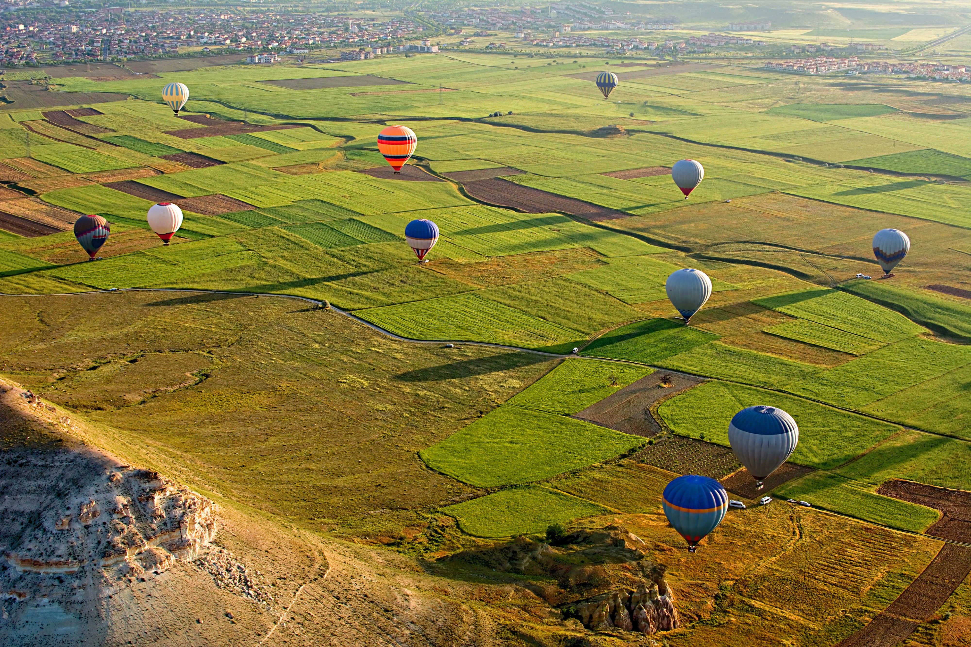 Hot air balloons over fields in Cappadocia, Turkey HD Wallpaper