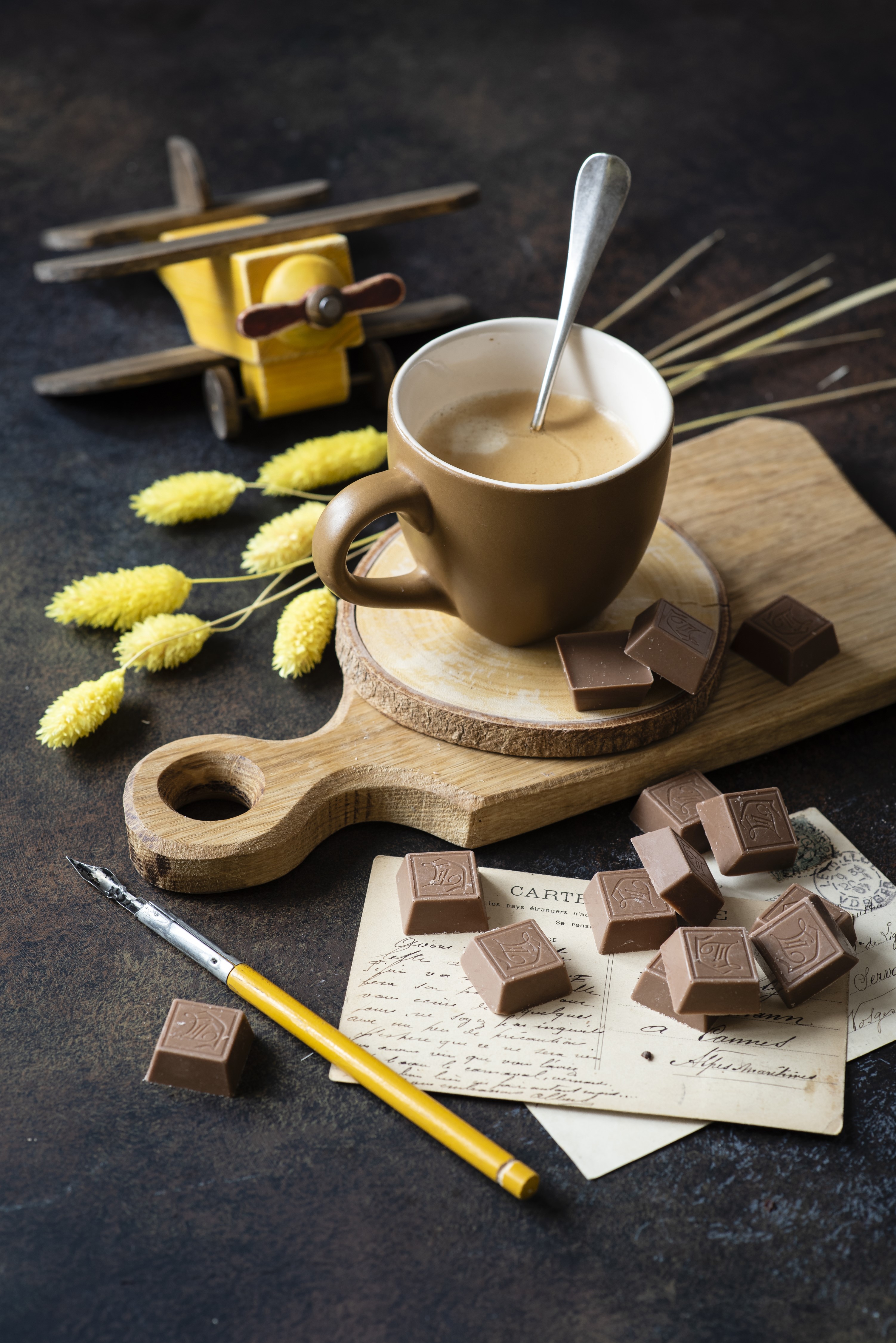 Cup of coffee with chocolates and a toy airplane HD Phone Wallpaper
