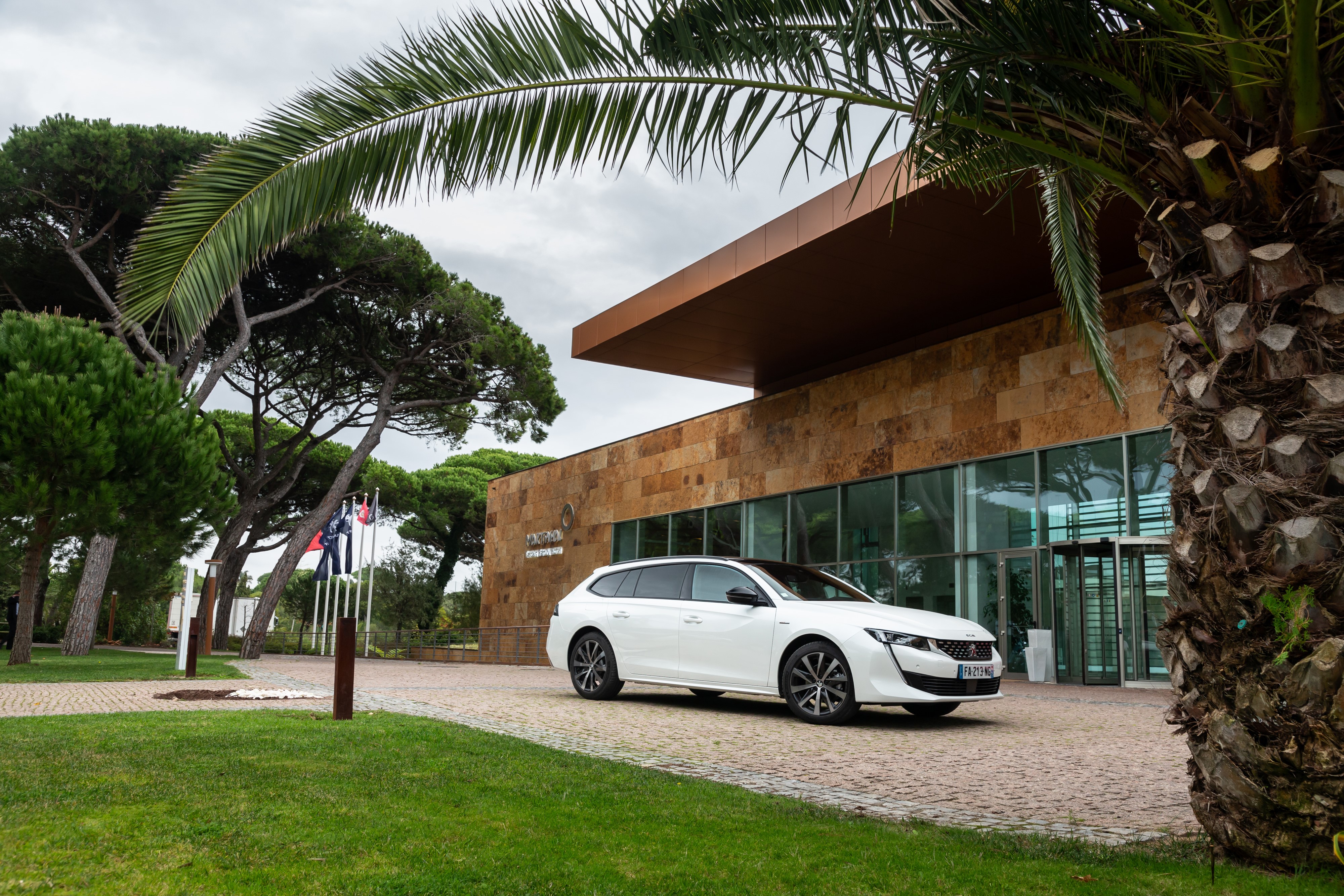 White Peugeot 508 SW GT Line parked outside building HD Wallpaper