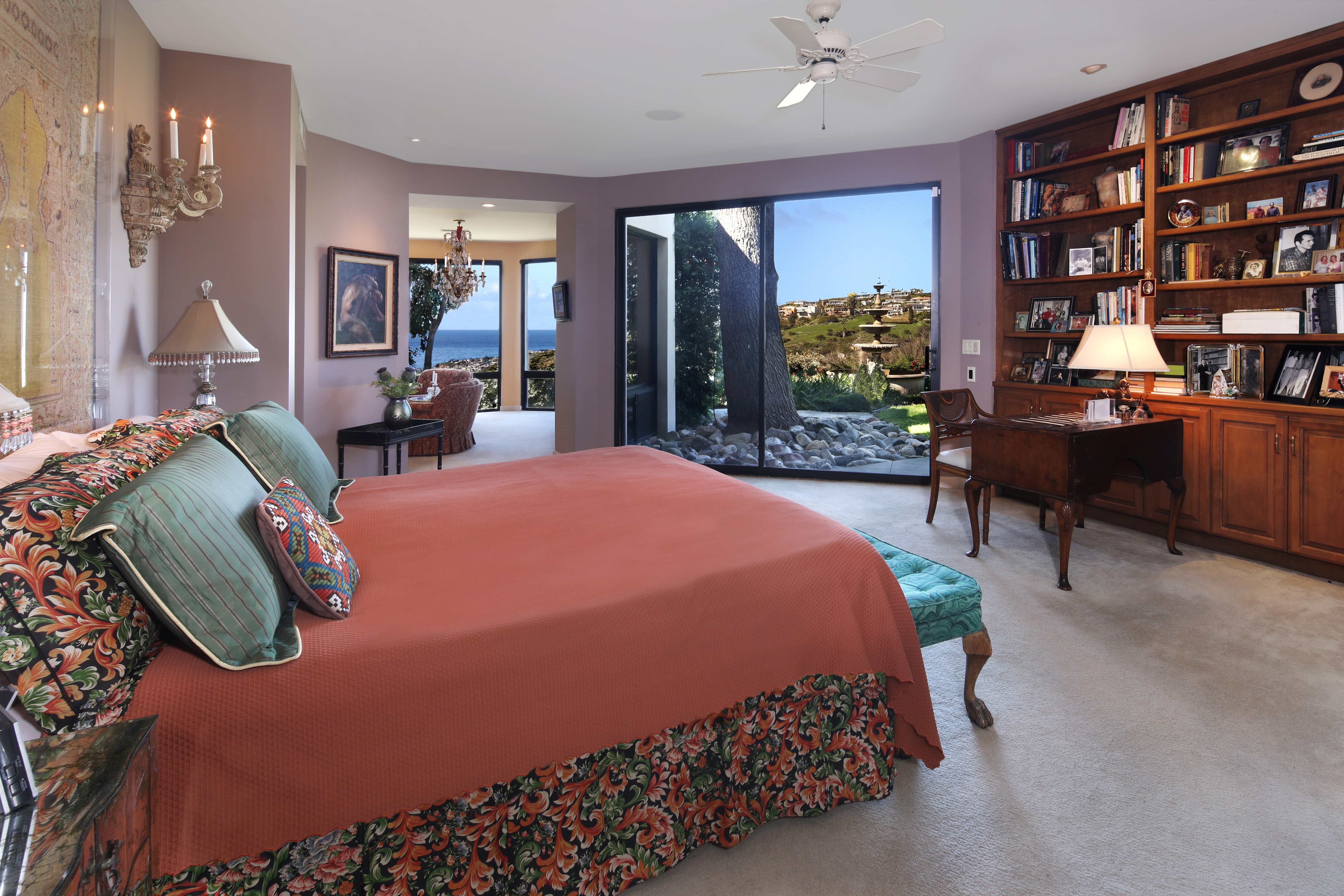 Bedroom with a large bed, bookshelves, and ocean view HD Wallpaper