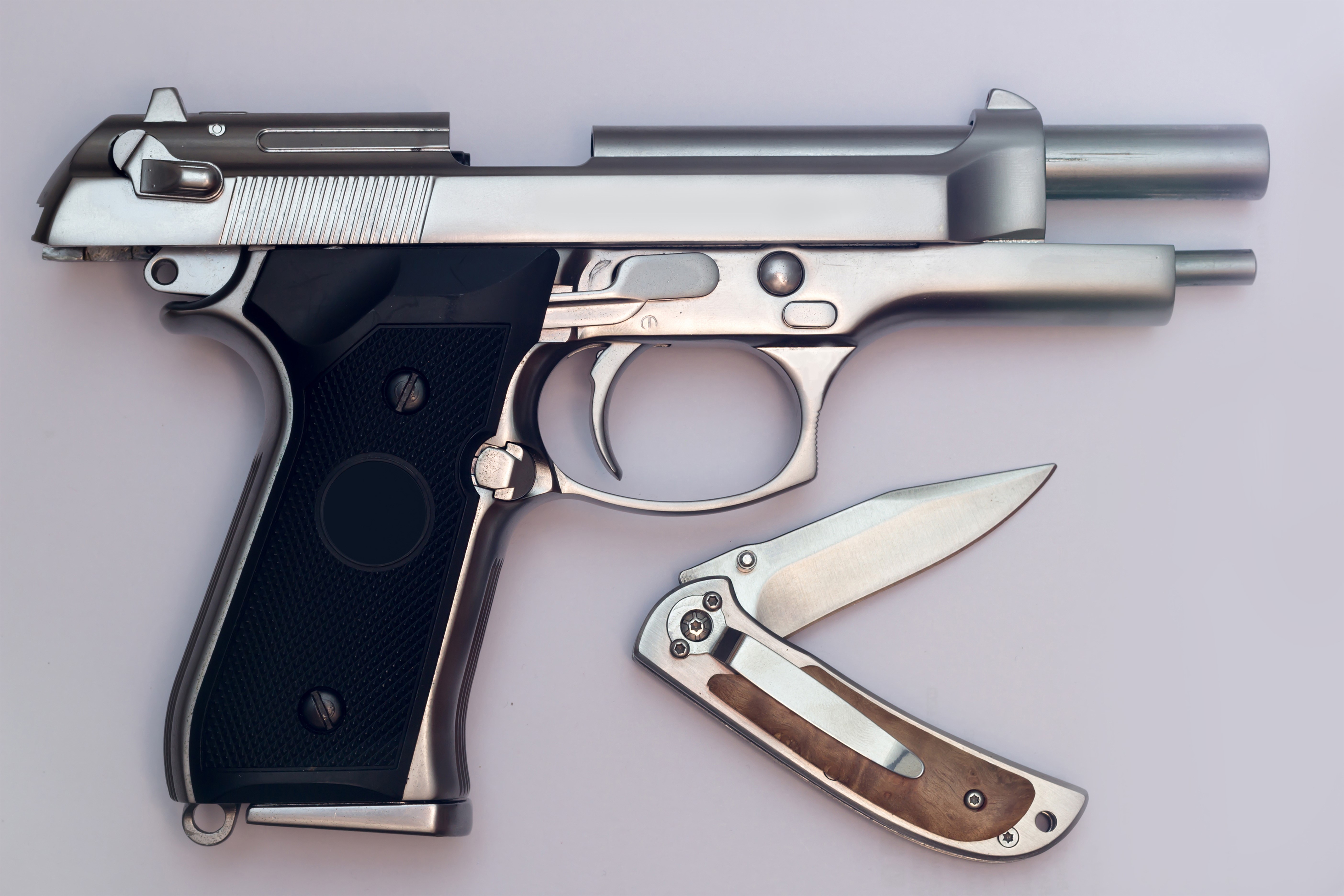 Pistol and folding knife on gray background HD Wallpaper
