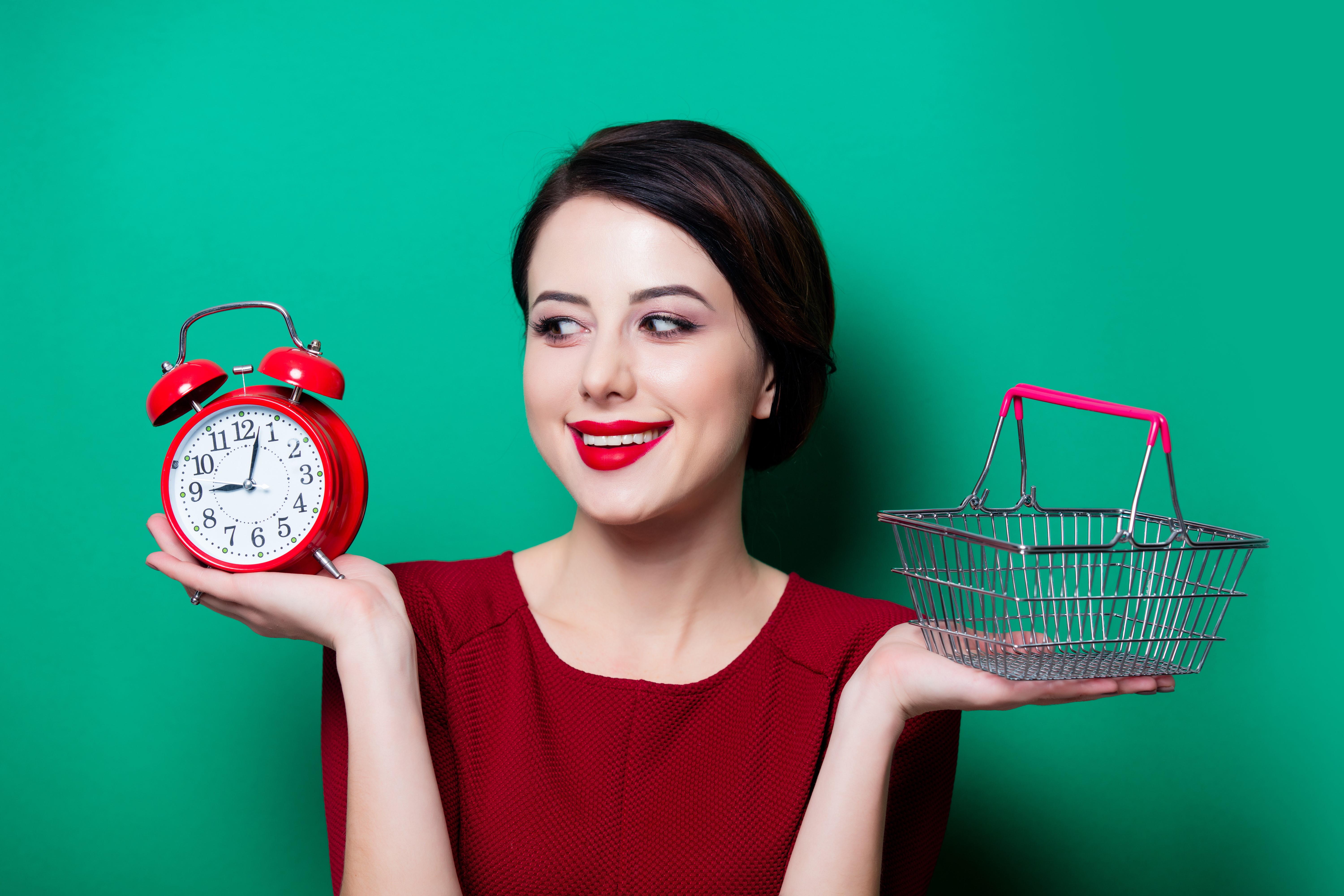 Woman holding an alarm clock and a shopping basket HD Wallpaper