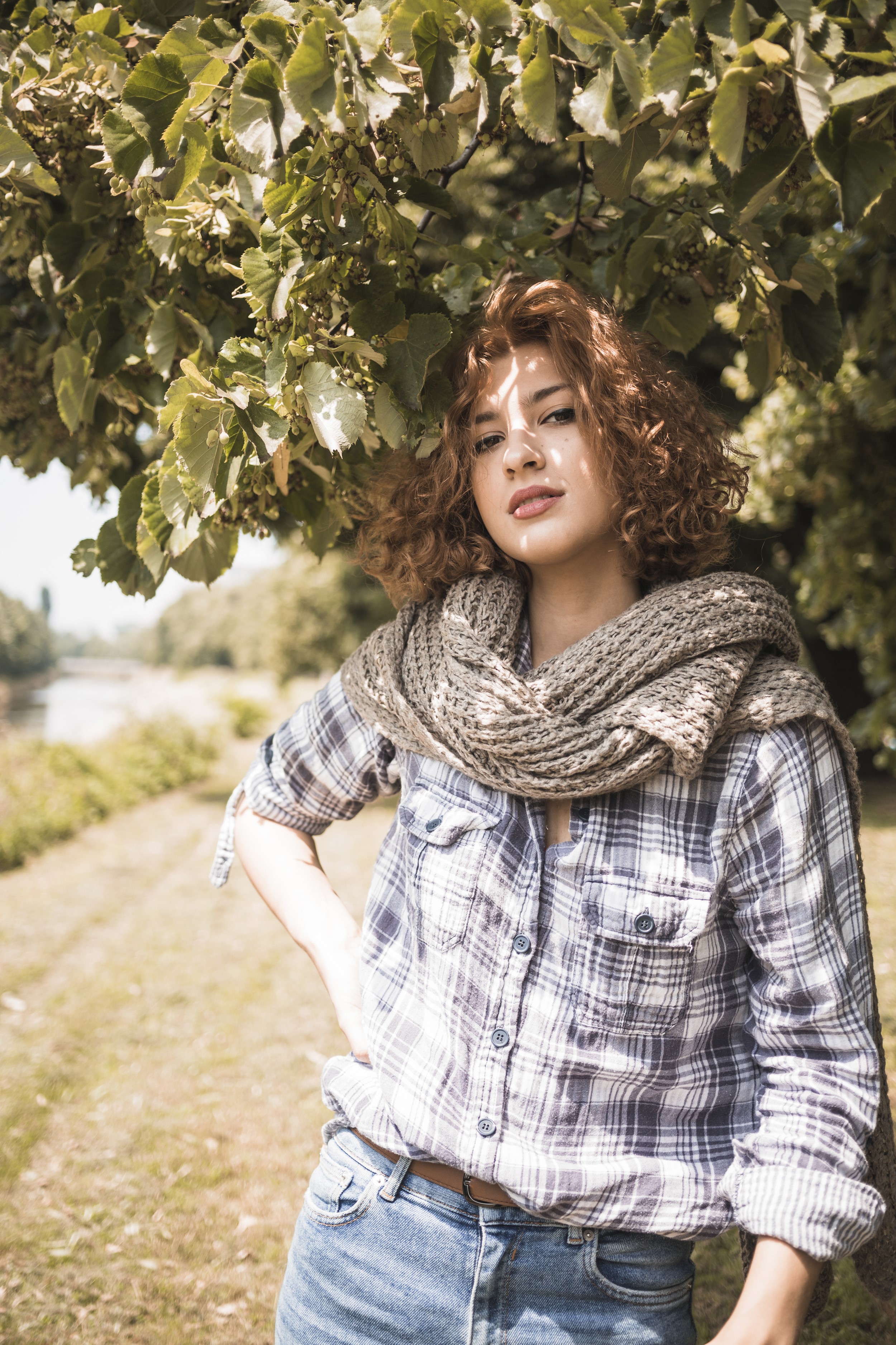 Woman with curly brown hair wearing a scarf and plaid shirt HD Phone Wallpaper