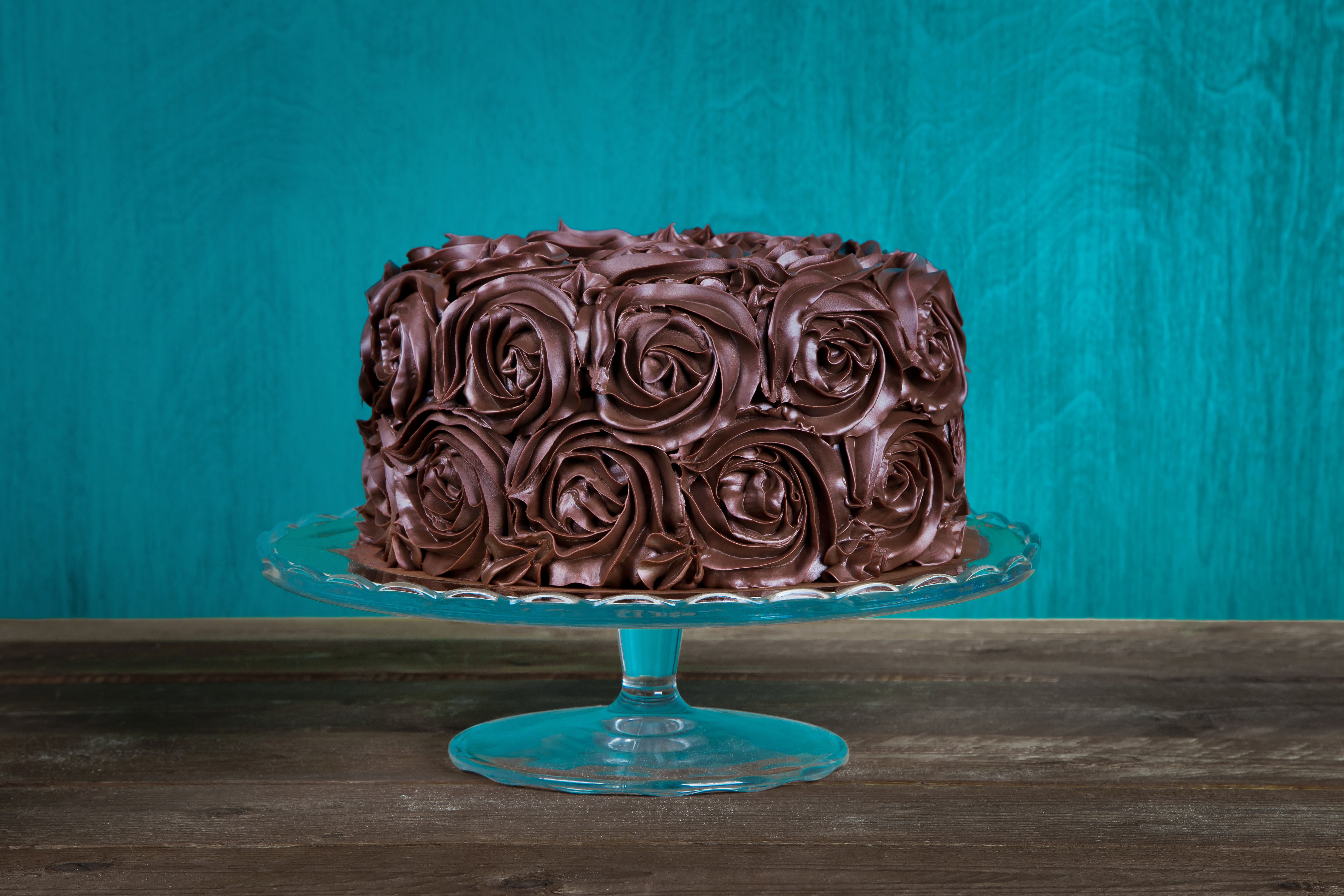 Chocolate cake with rose frosting on a cake stand HD Wallpaper