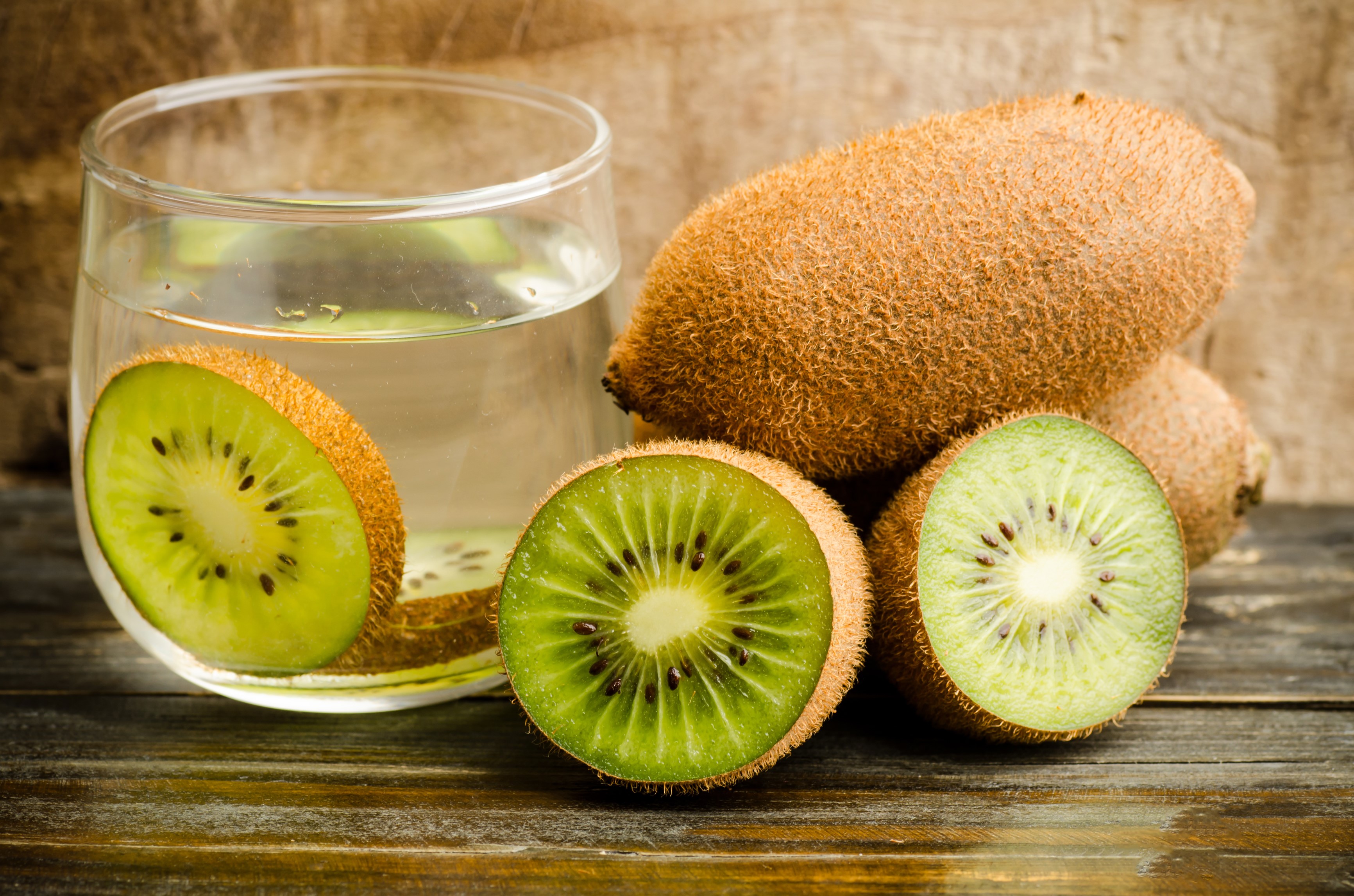 Kiwi slices and whole kiwis next to a glass of kiwi juice HD Wallpaper