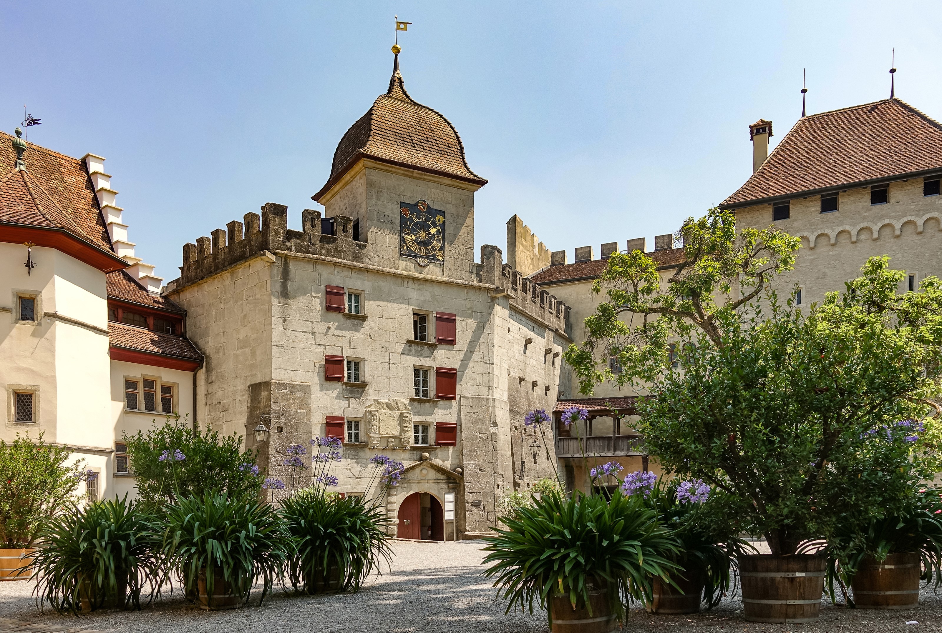 Lenzburg Castle courtyard with plants and trees HD Wallpaper