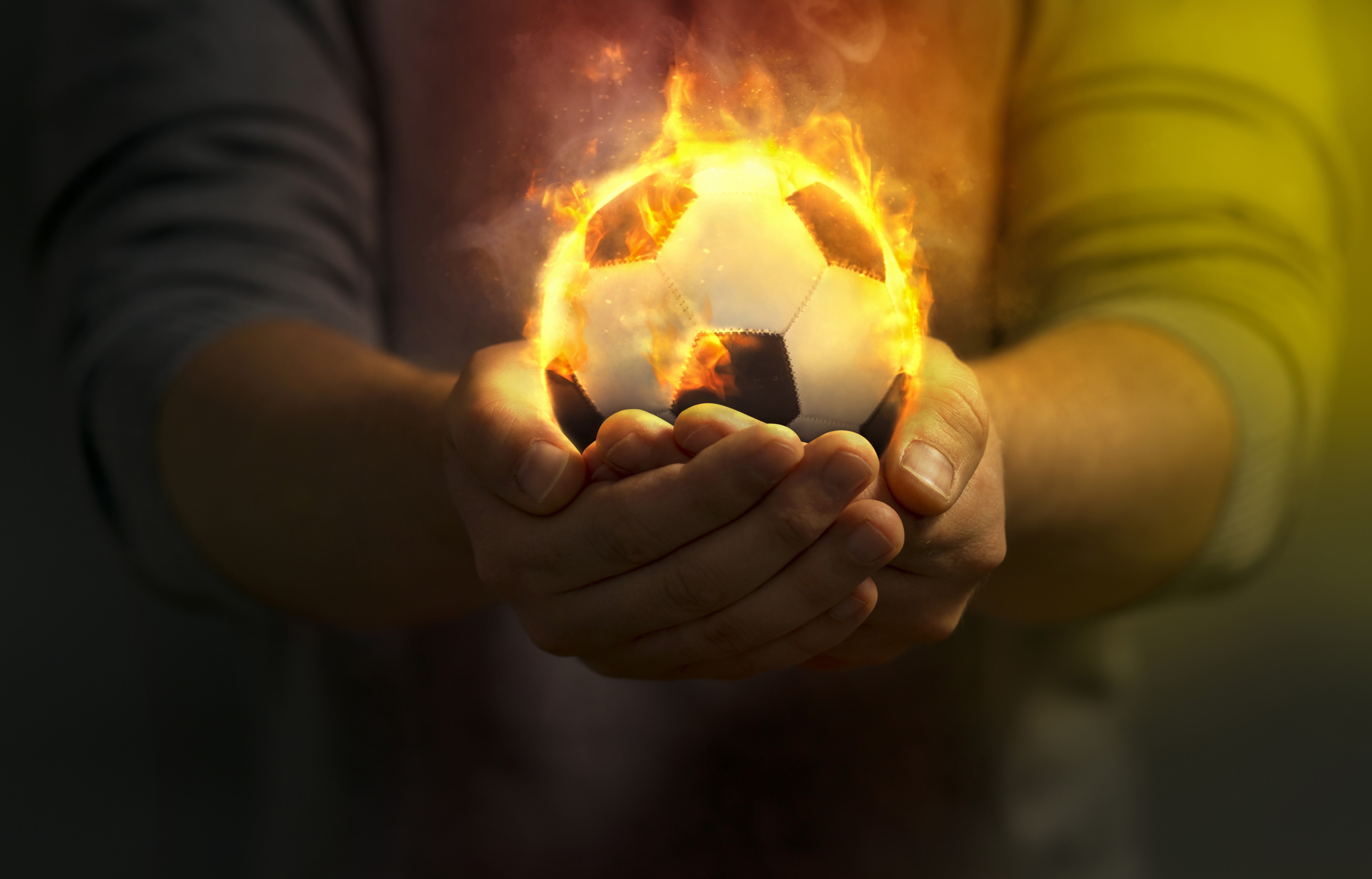 Soccer ball on fire held in hands HD Wallpaper