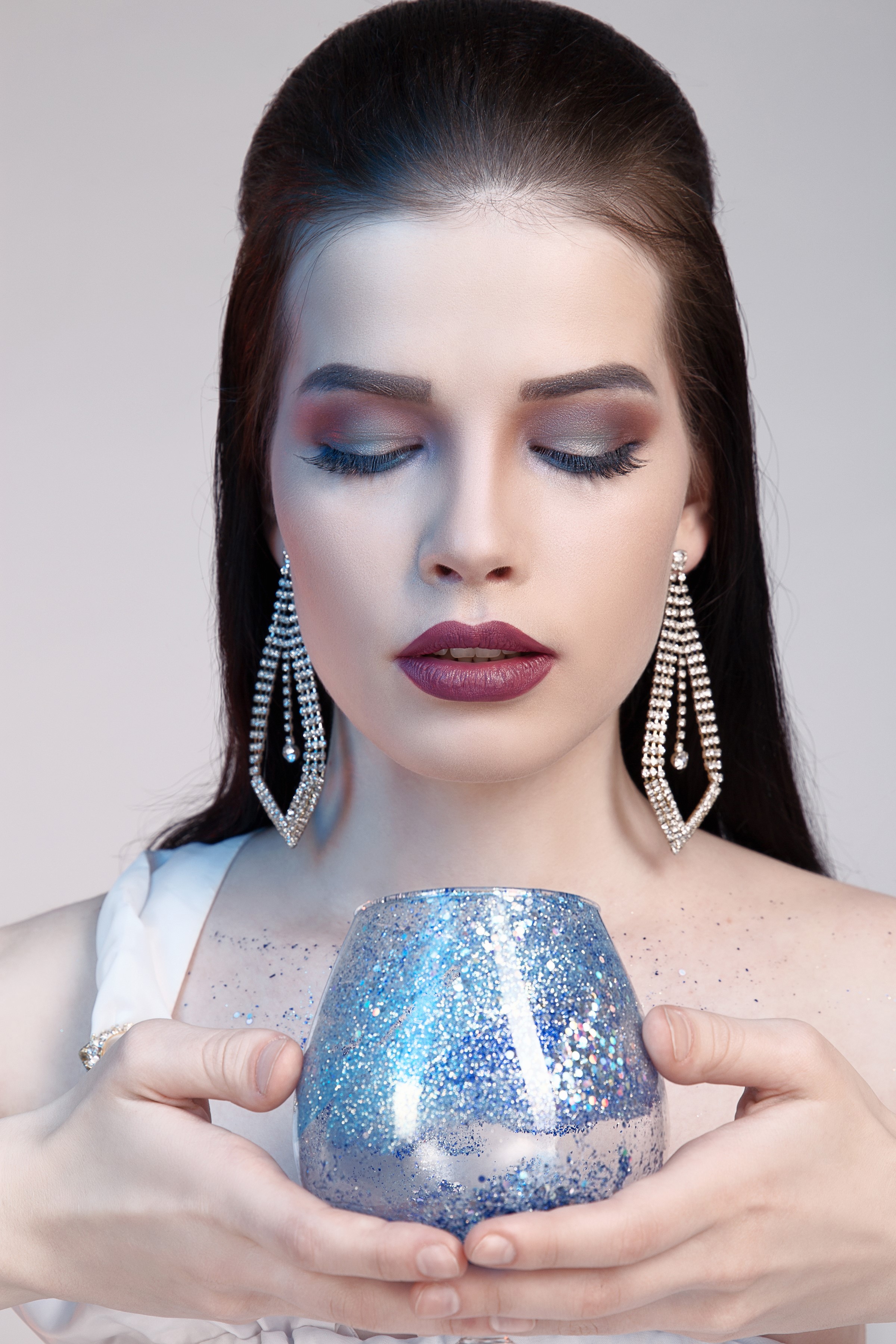 Woman with dramatic makeup and jewelry holding a glittery vase HD Phone Wallpaper