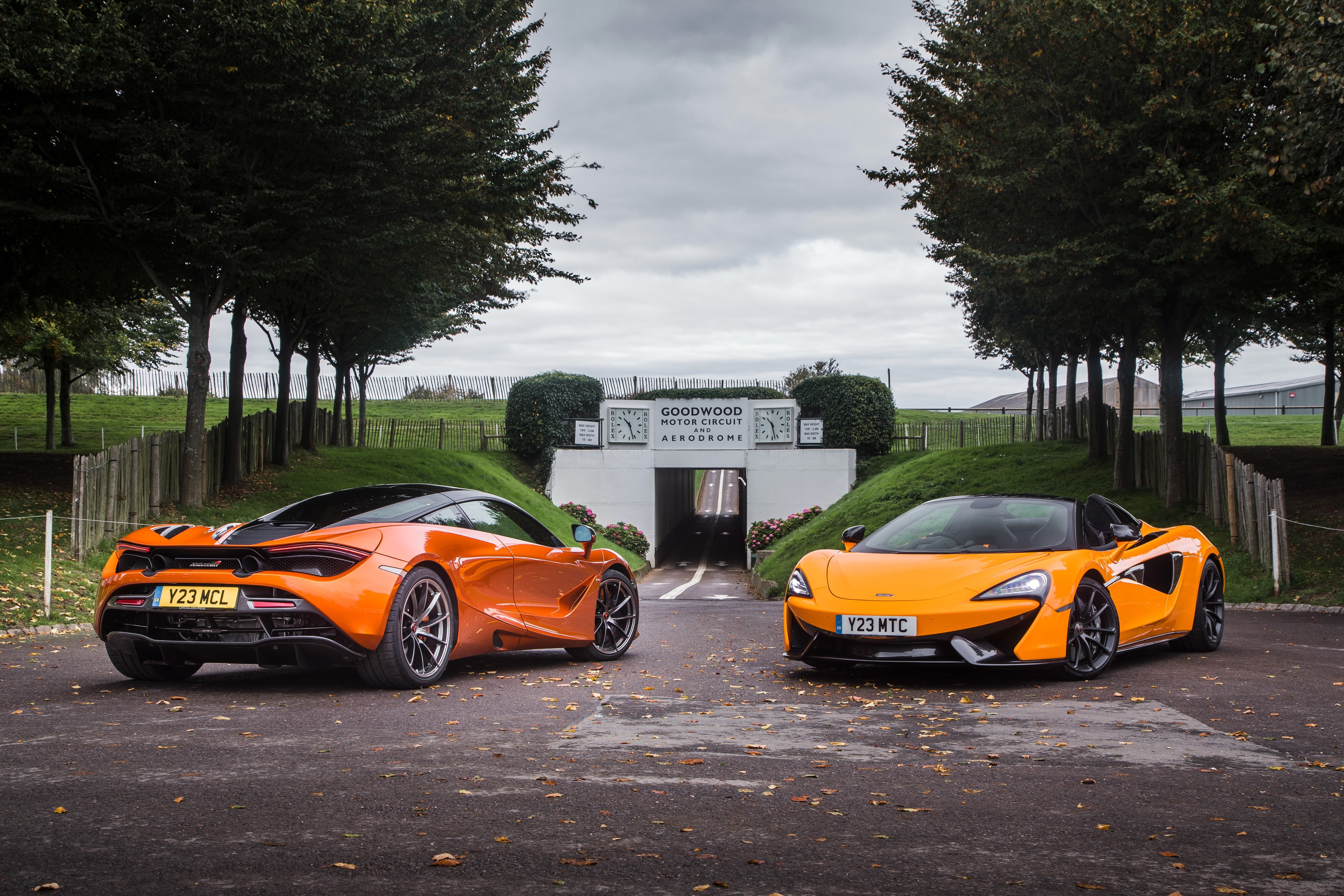 Two orange McLaren cars at Goodwood Motor Circuit HD Wallpaper