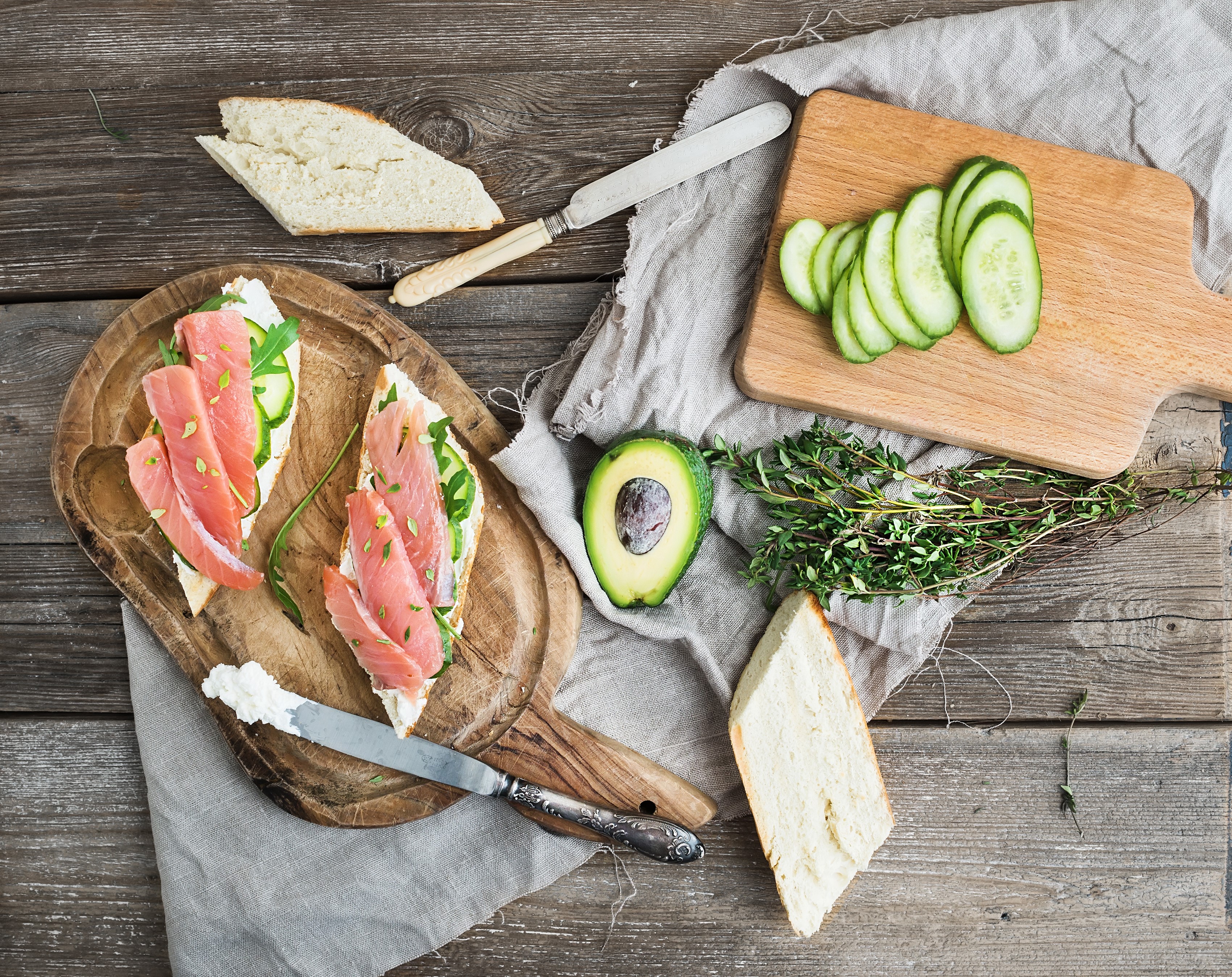 Smoked salmon sandwiches with avocado and cucumber on a wooden board HD Wallpaper