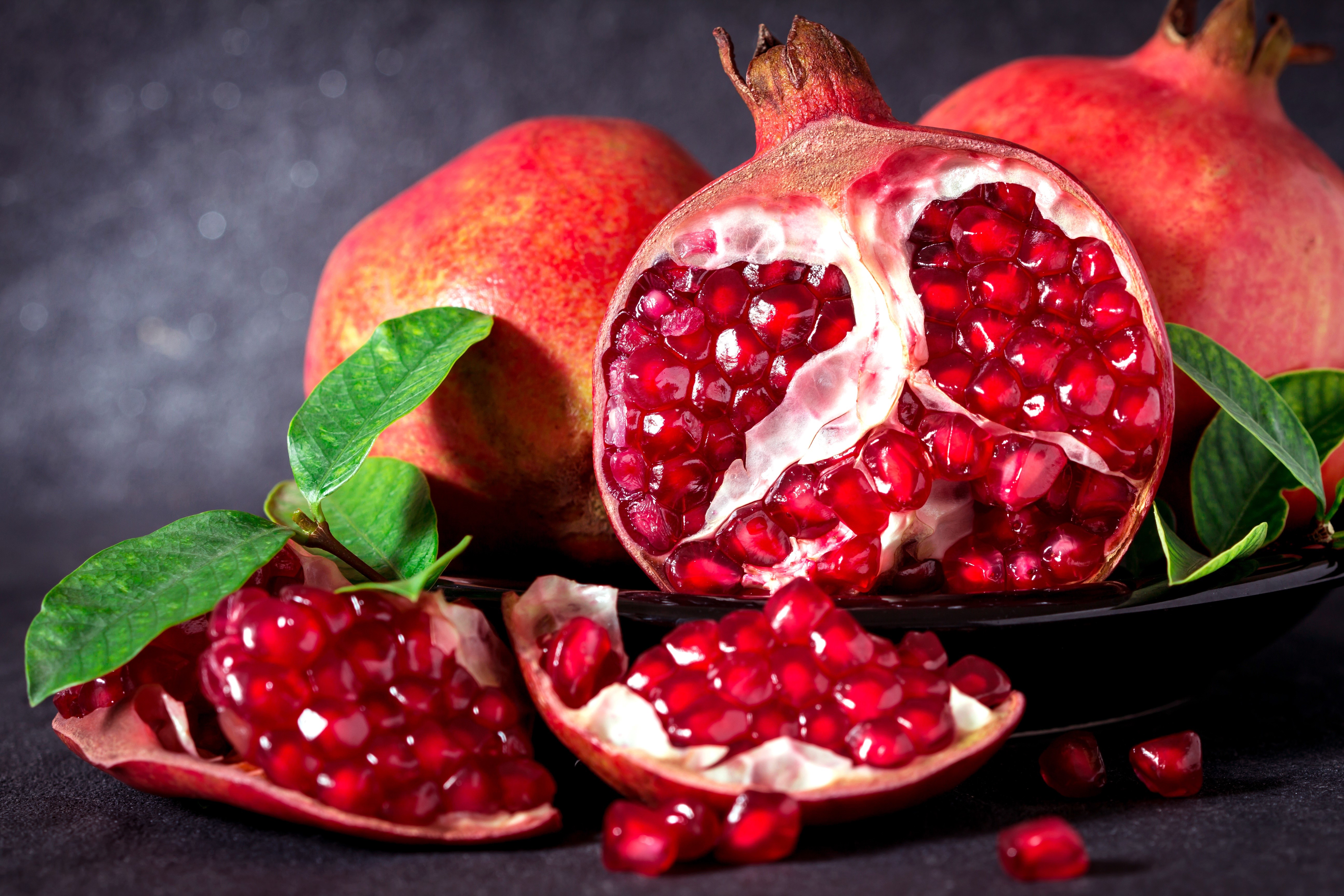 Pomegranates with leaves on a dark background HD Wallpaper