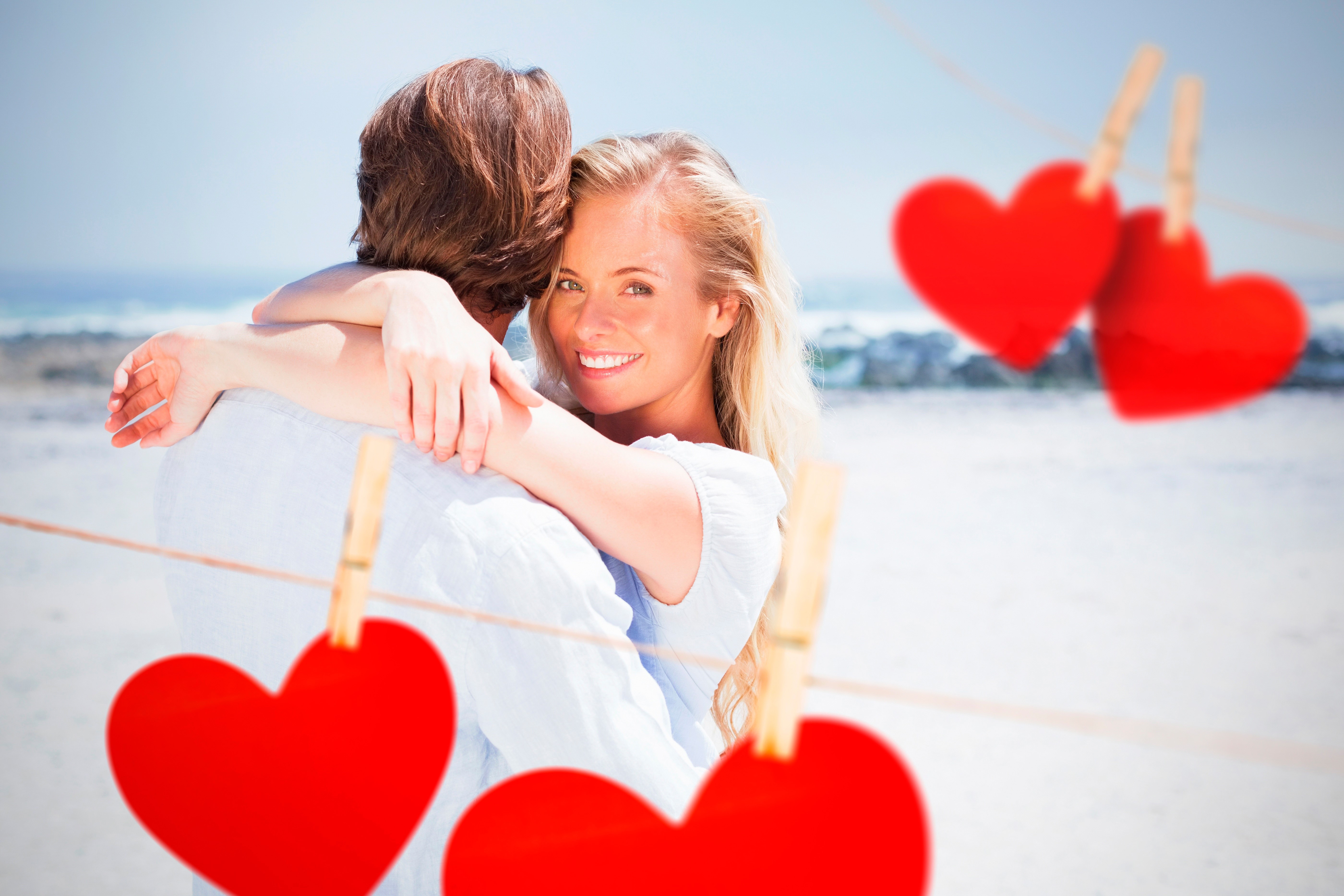 Couple hugging on a beach with hearts HD Wallpaper