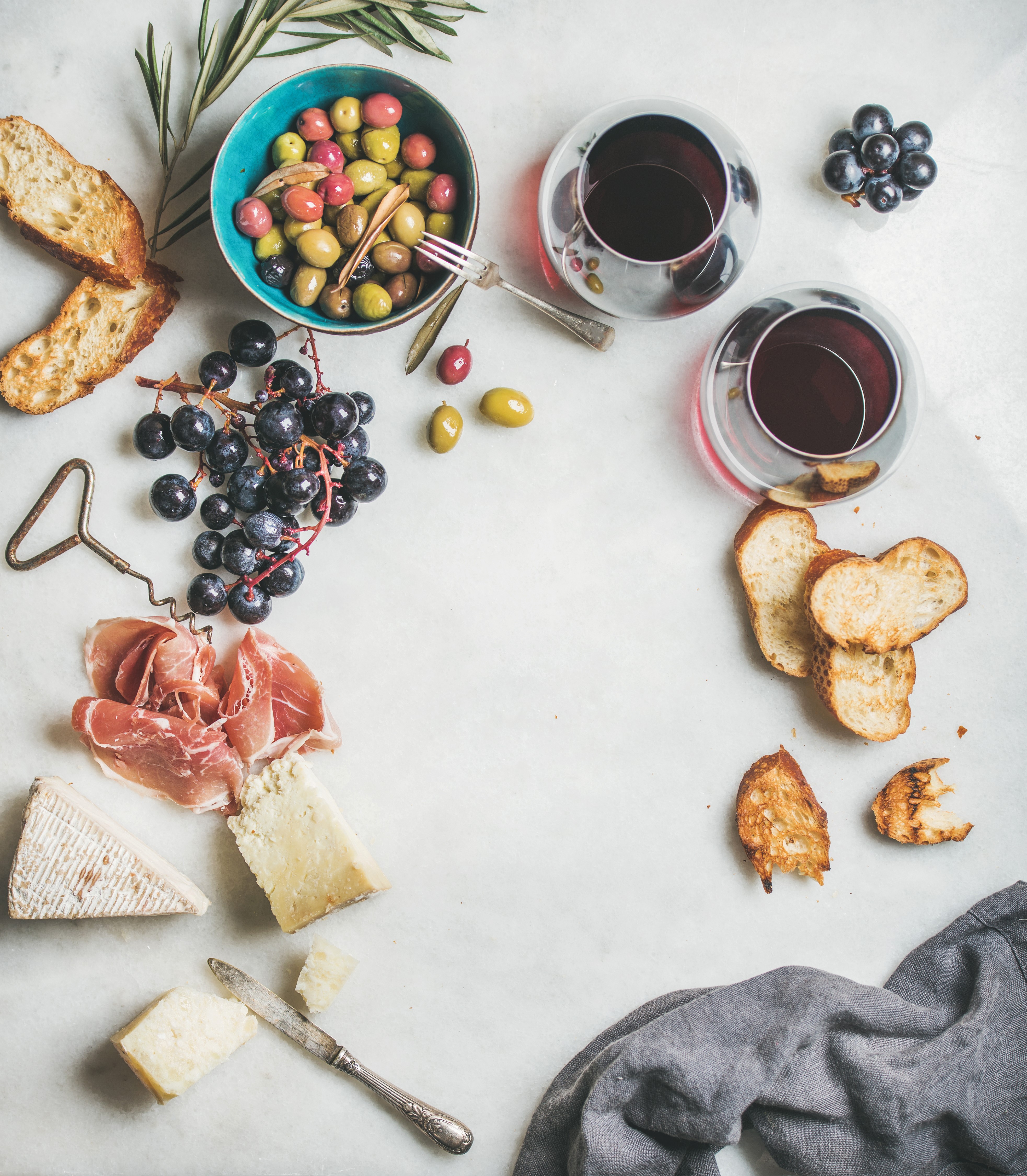 Charcuterie board with wine, cheese, ham, olives, and bread HD Wallpaper