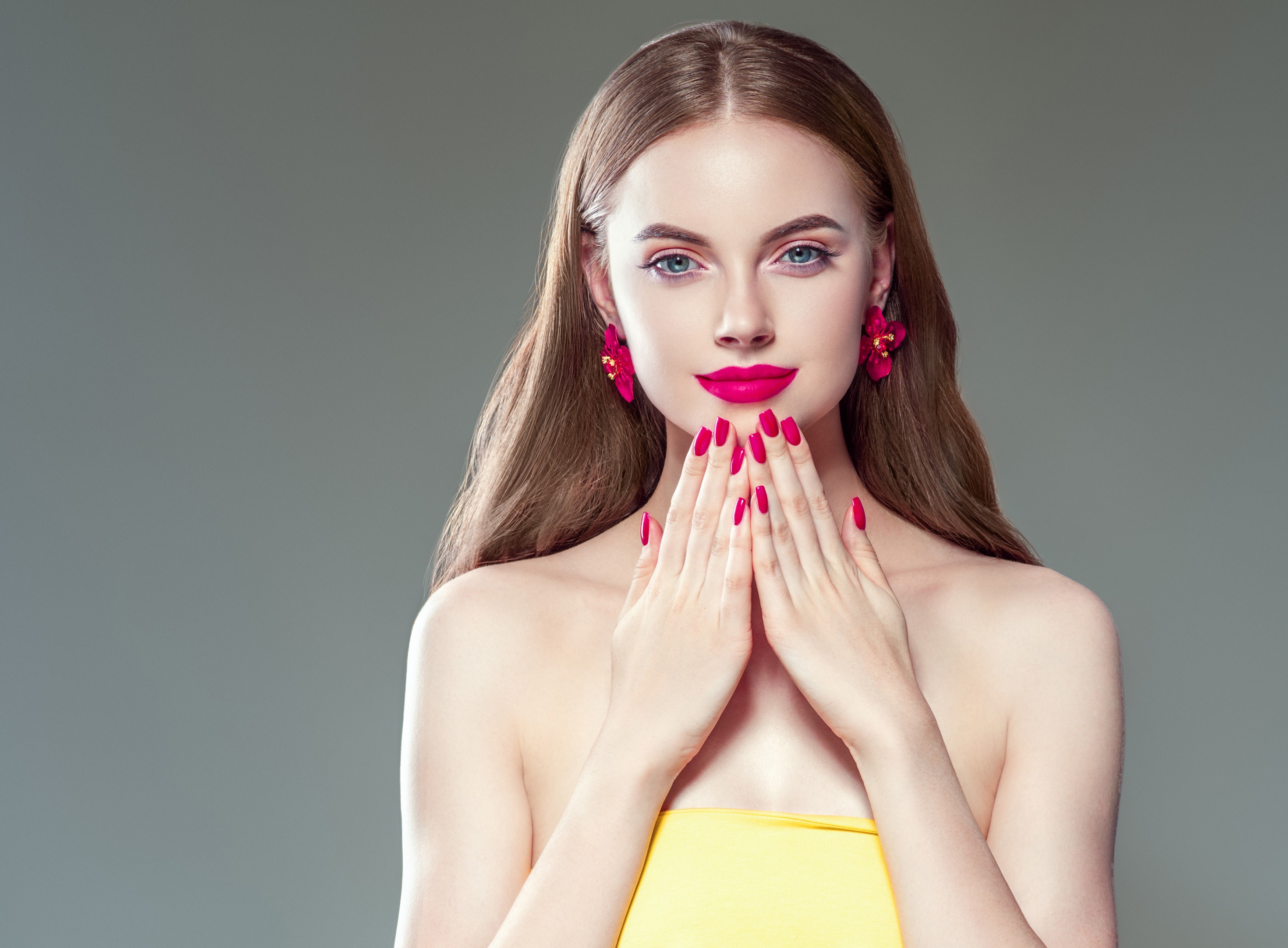 Woman with red lips and nails, pink earrings HD Wallpaper