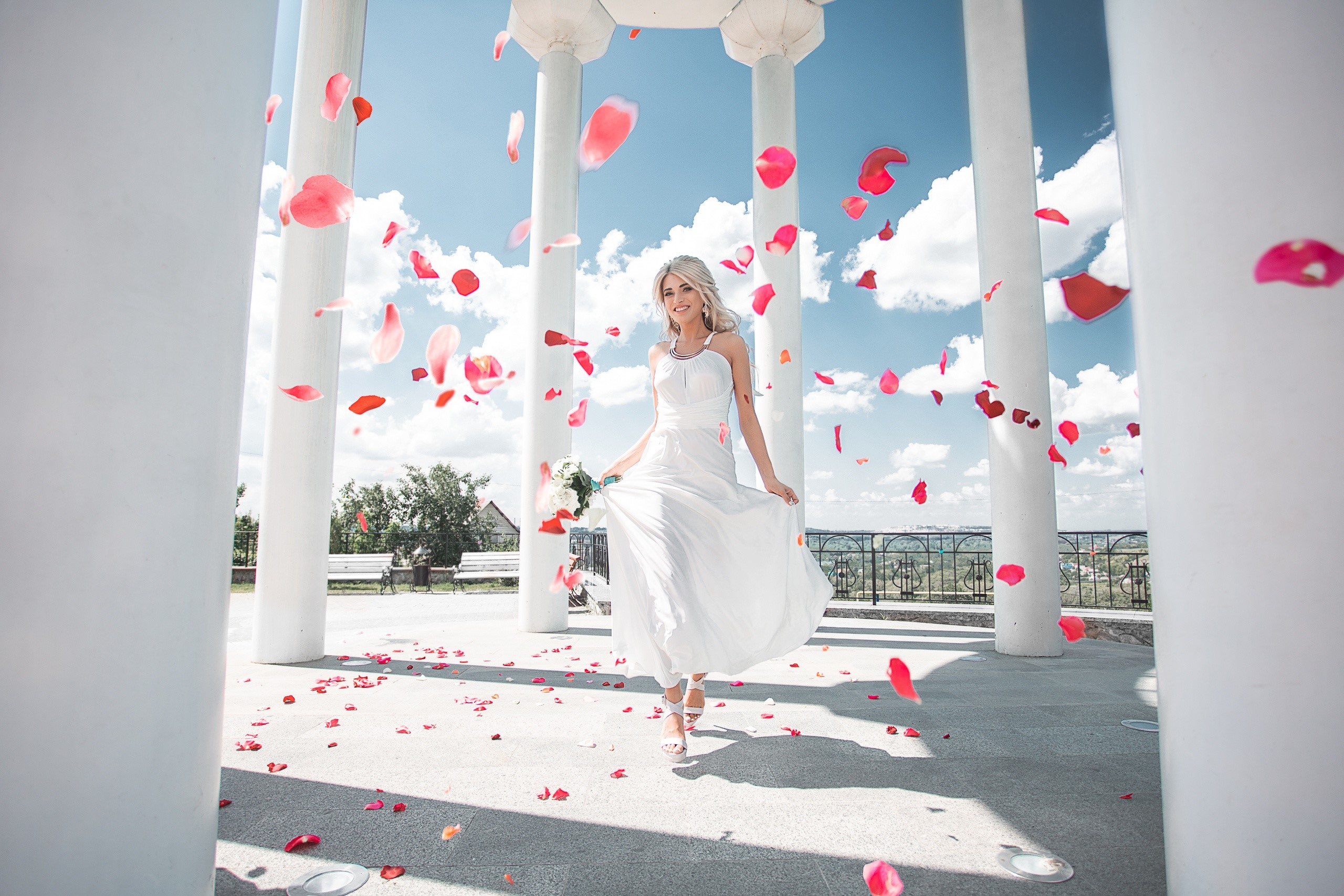 Bride in white dress with falling petals HD Wallpaper