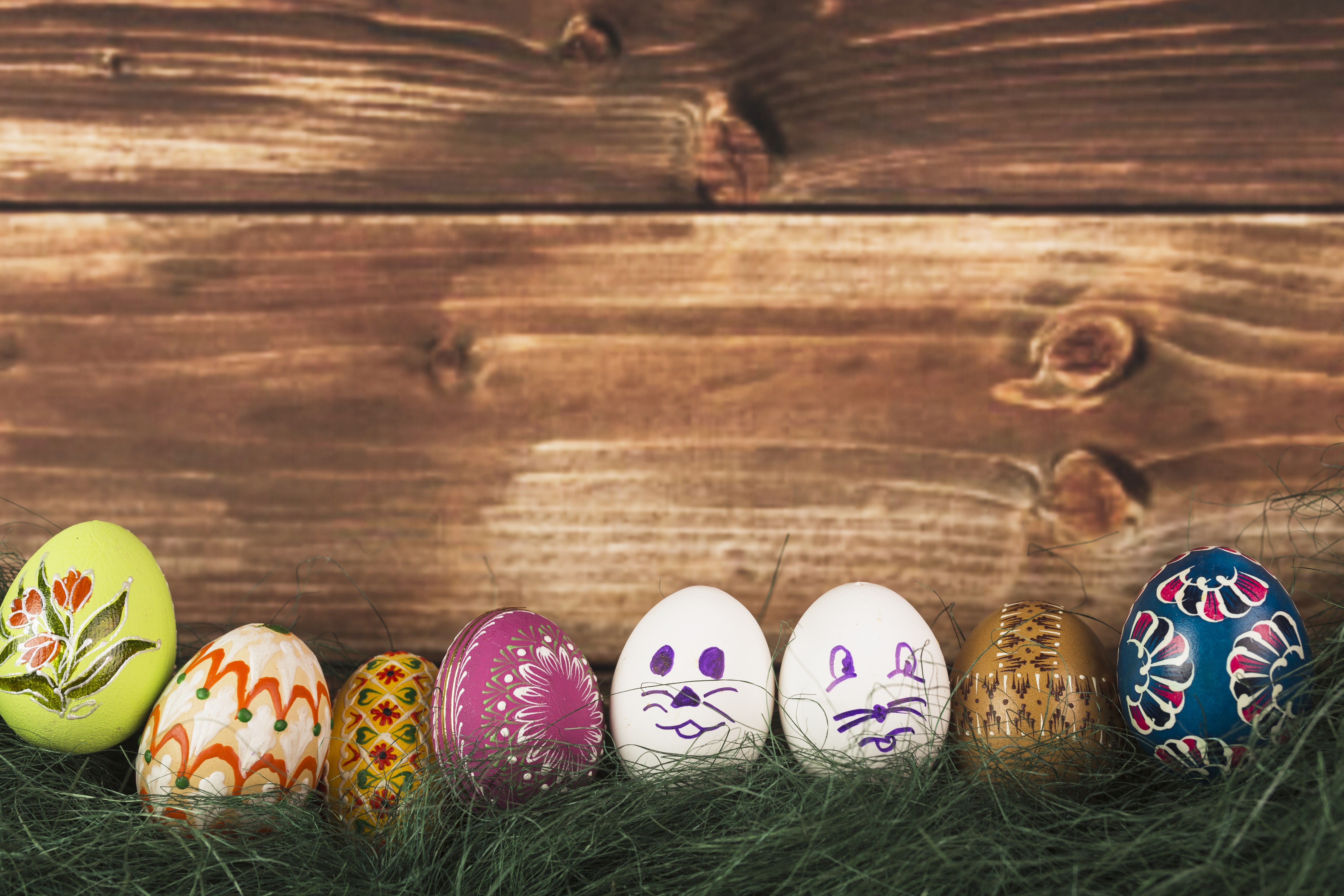 Easter eggs on grass with wood plank background HD Wallpaper