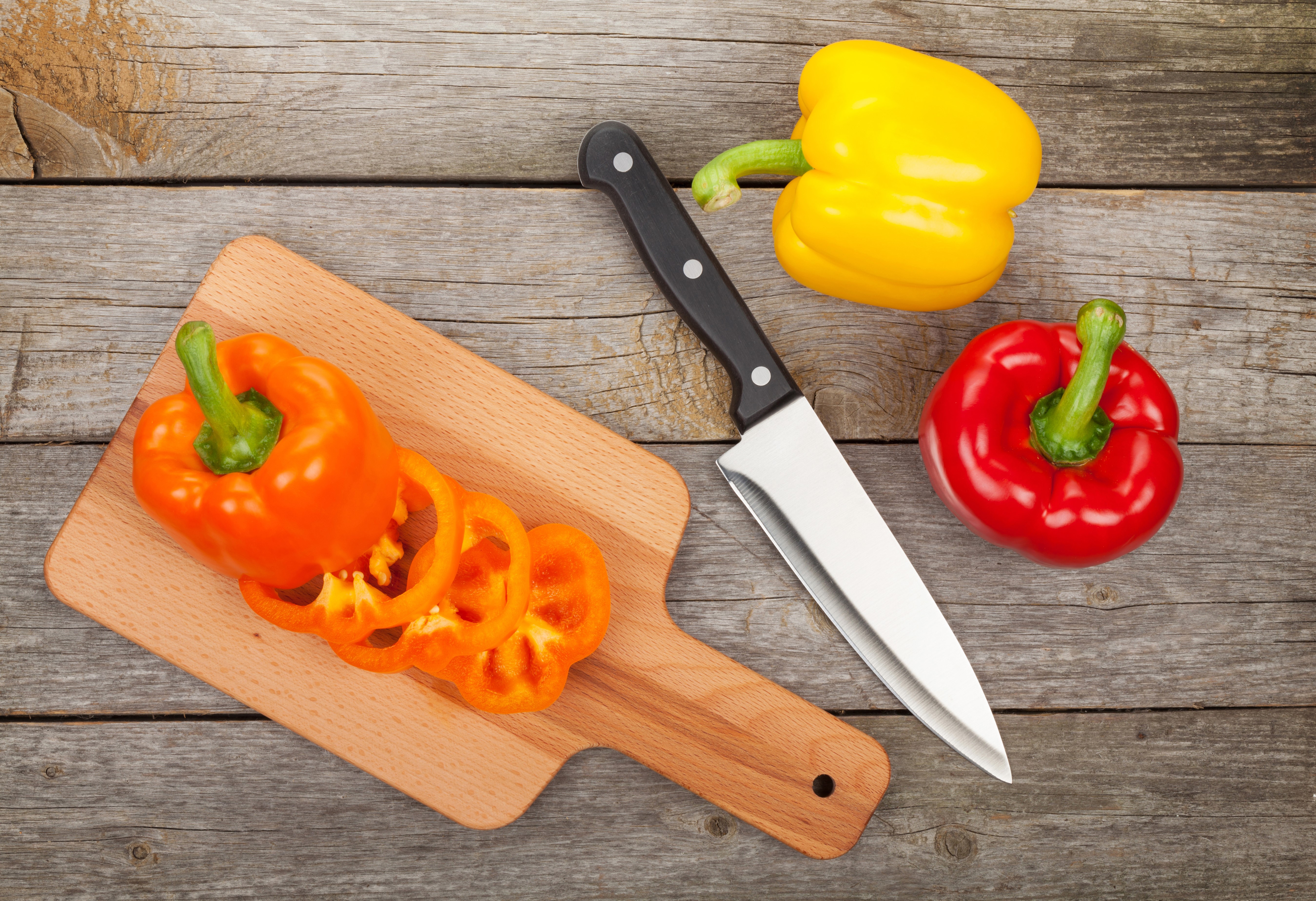 Bell peppers and knife on wood planks HD Wallpaper