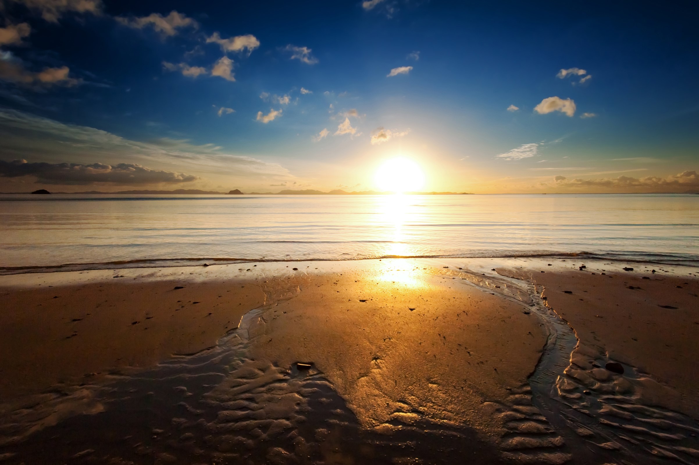 Sunset over the ocean with a sandy beach HD Wallpaper