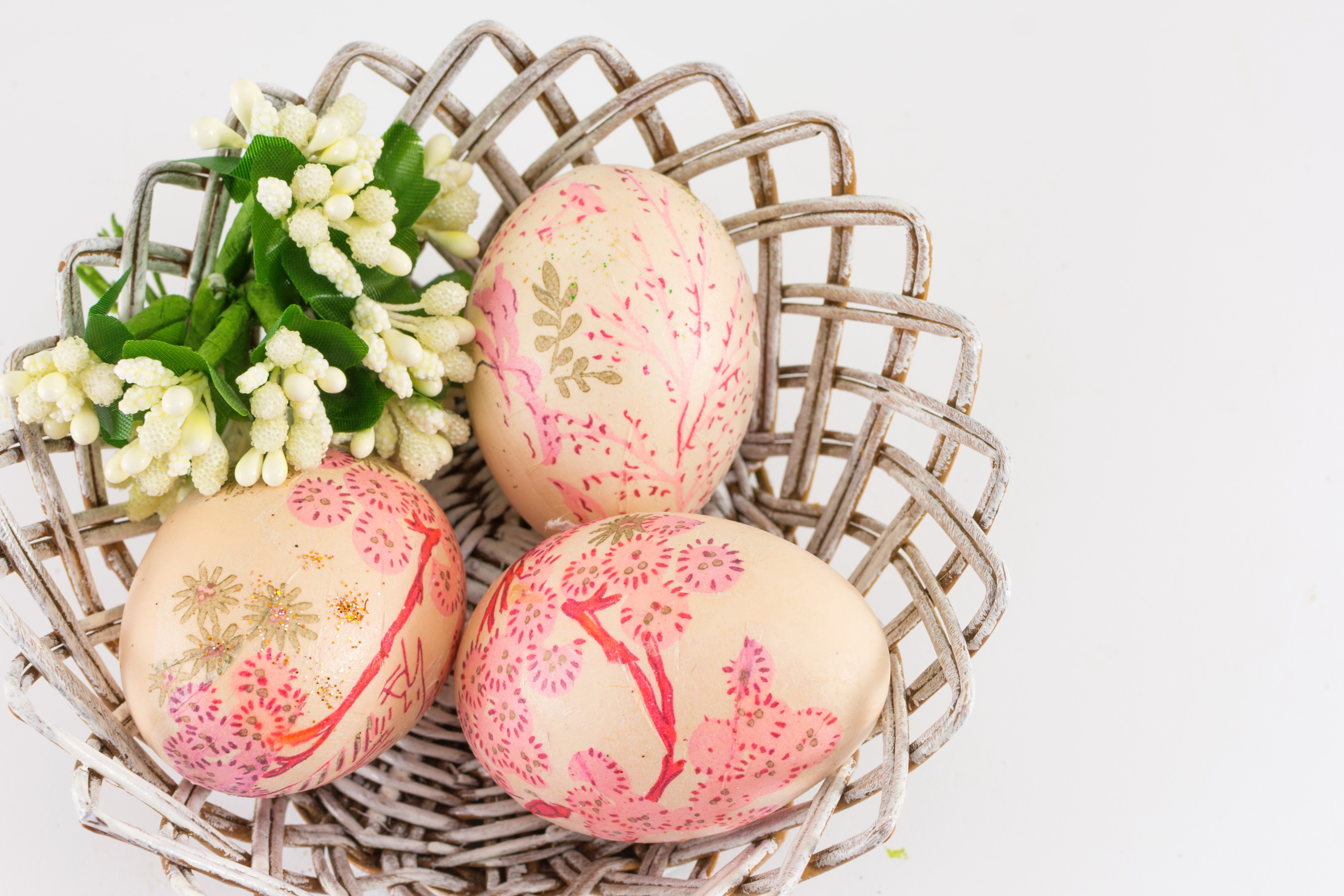 Three decorated Easter eggs in a basket with flowers HD Wallpaper
