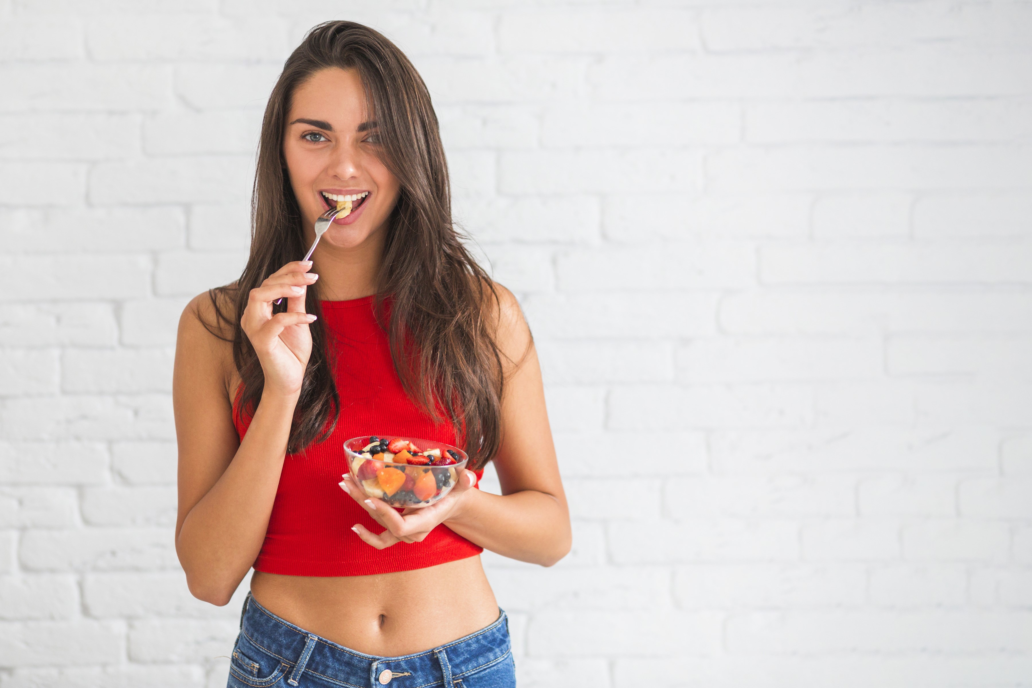 Woman eating fruit salad HD Wallpaper