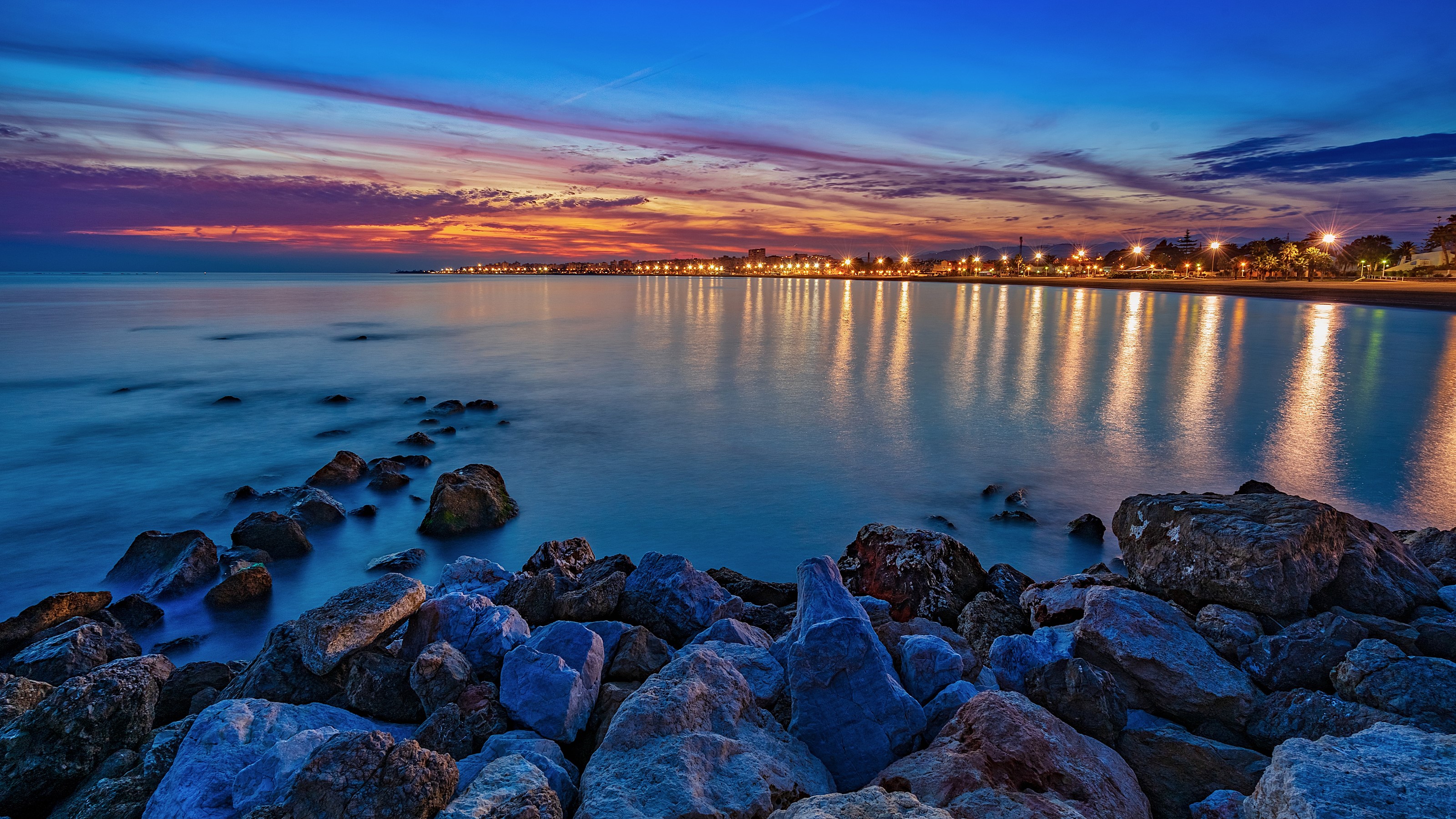 Torre del Mar coast at dusk with lights reflecting on the sea HD Wallpaper