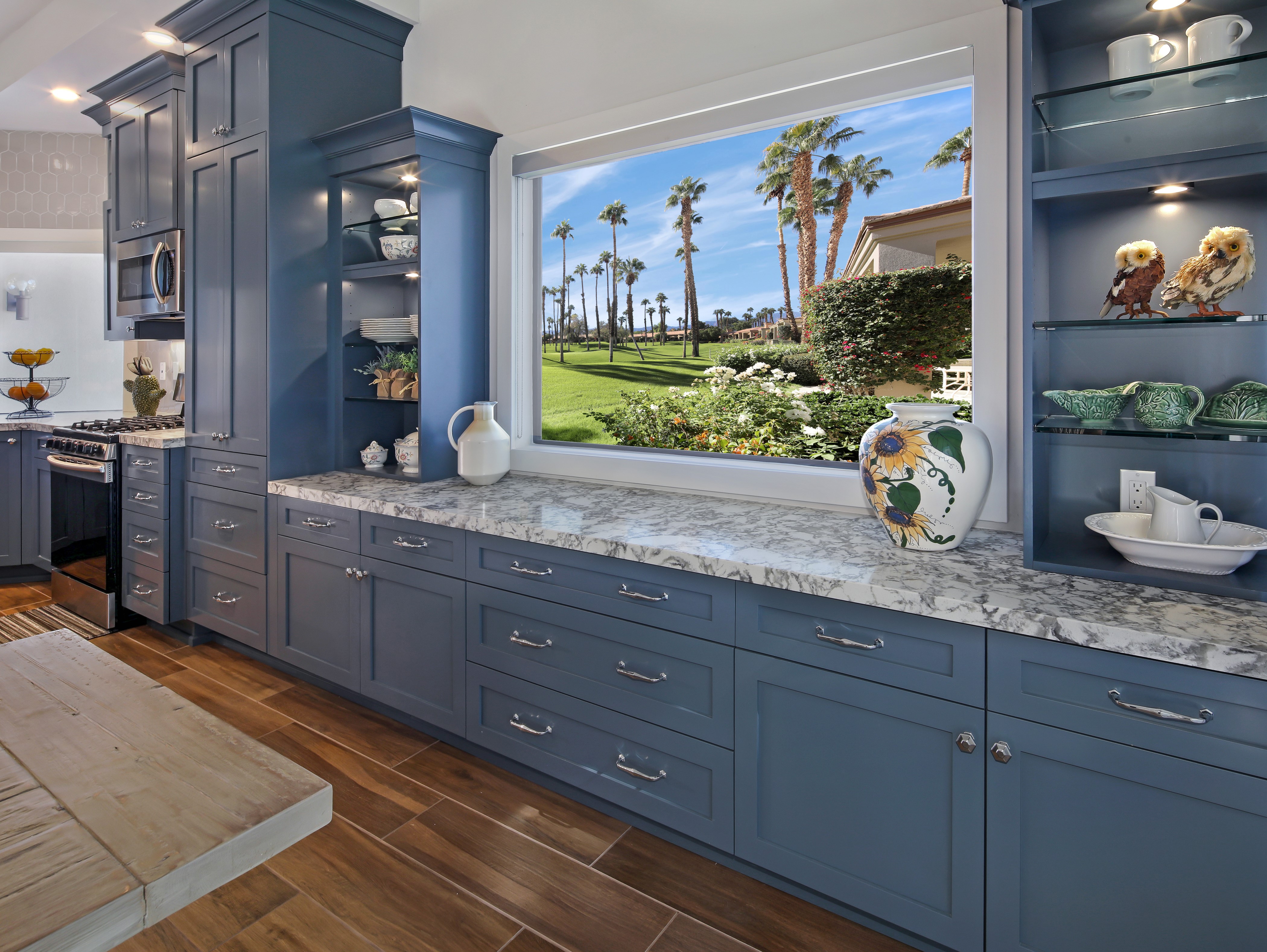 Kitchen with Blue Cabinets and Palm Tree View HD Wallpaper