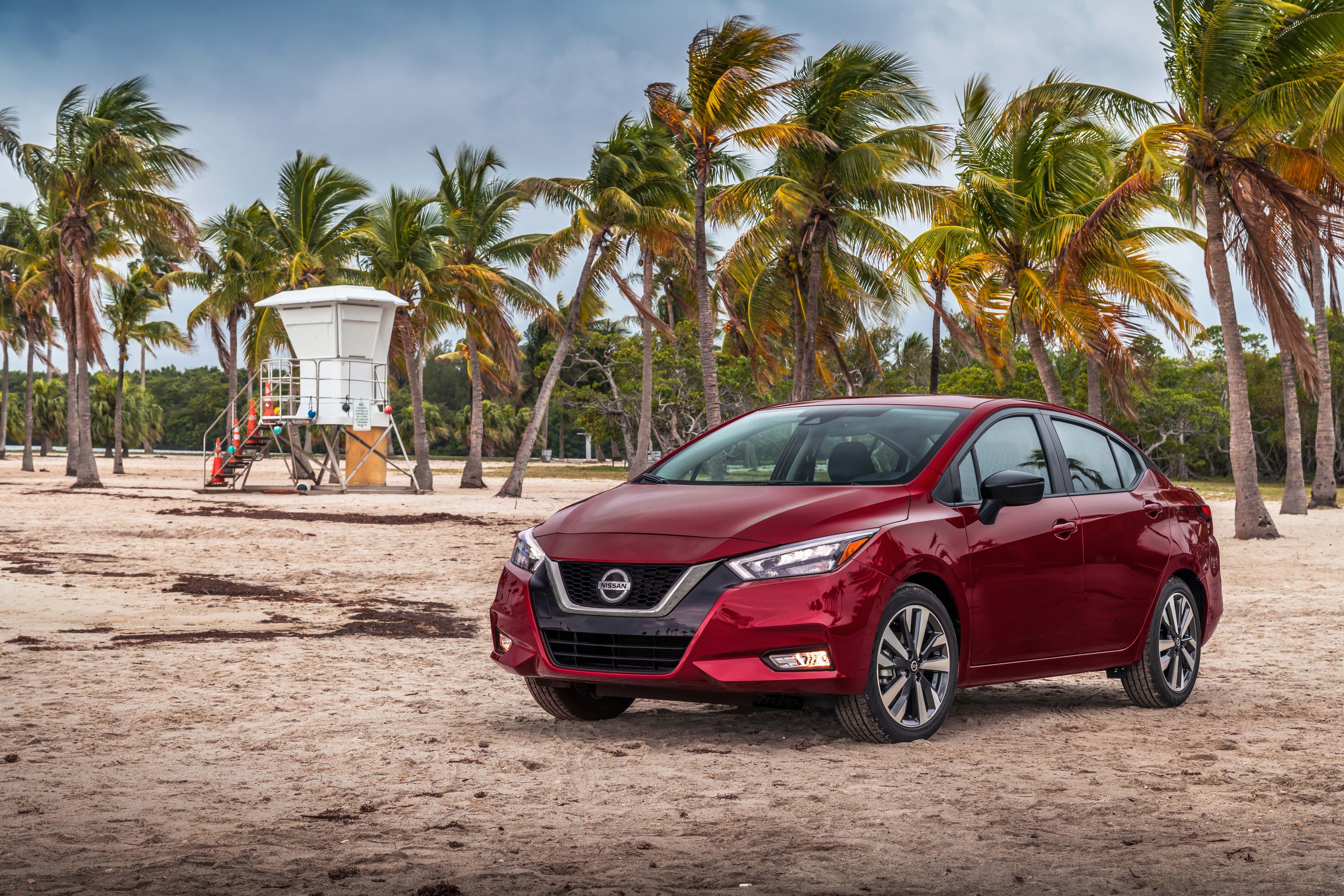 Red 2020 Nissan Versa SR on a beach HD Wallpaper
