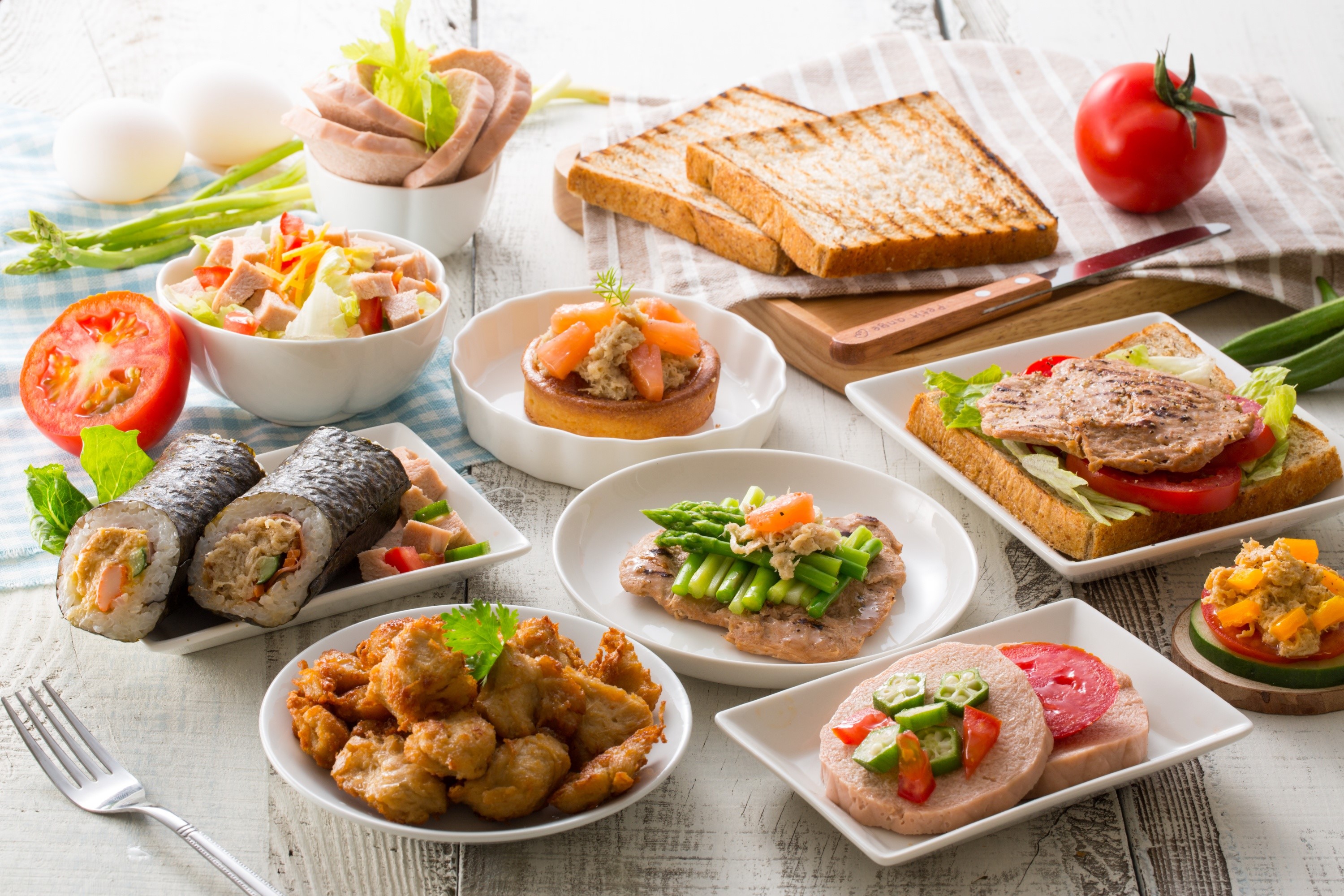Assortment of breakfast foods including sandwiches, sushi, and salad HD Wallpaper