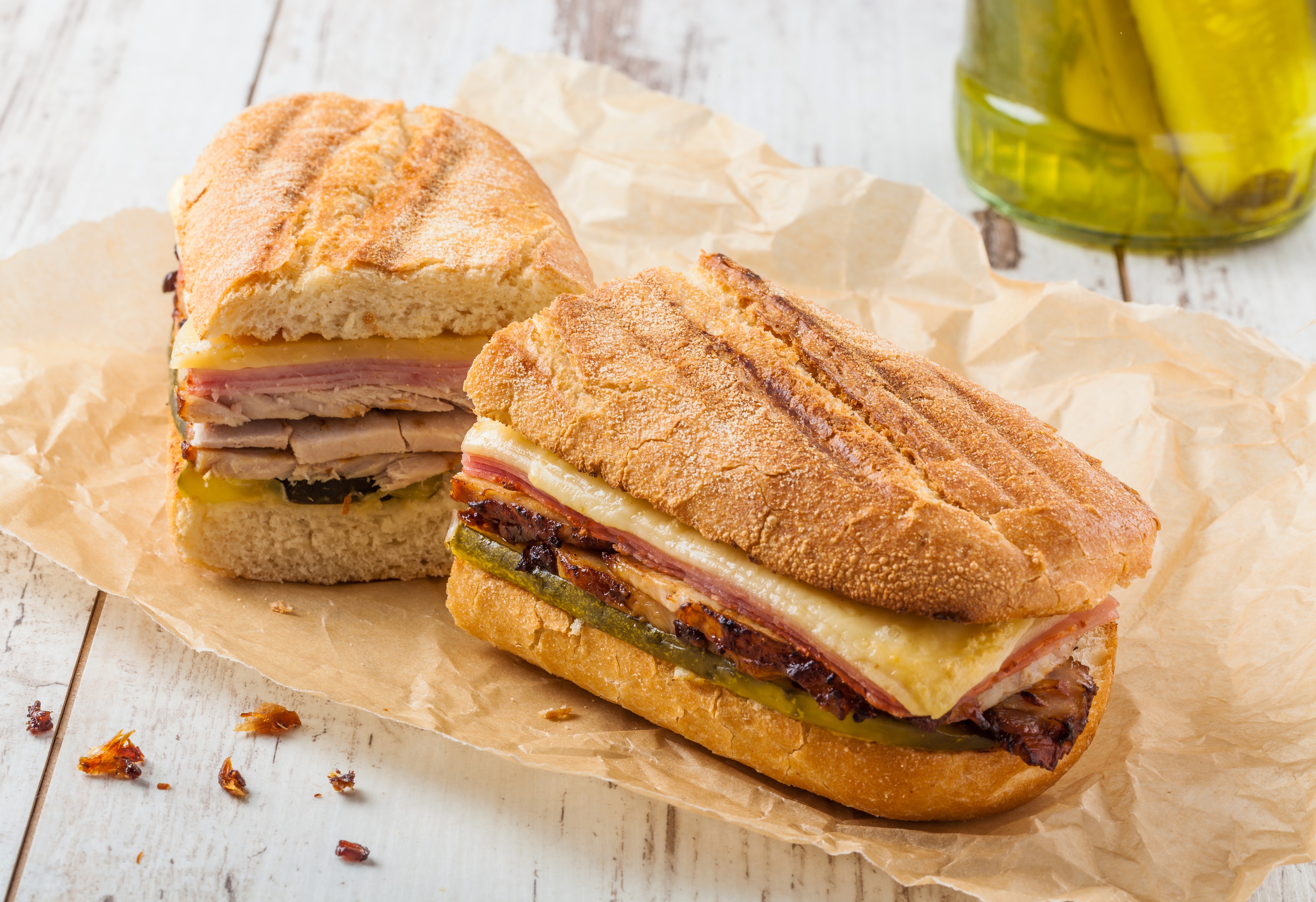 Two Cubano Sandwiches on Parchment Paper HD Wallpaper