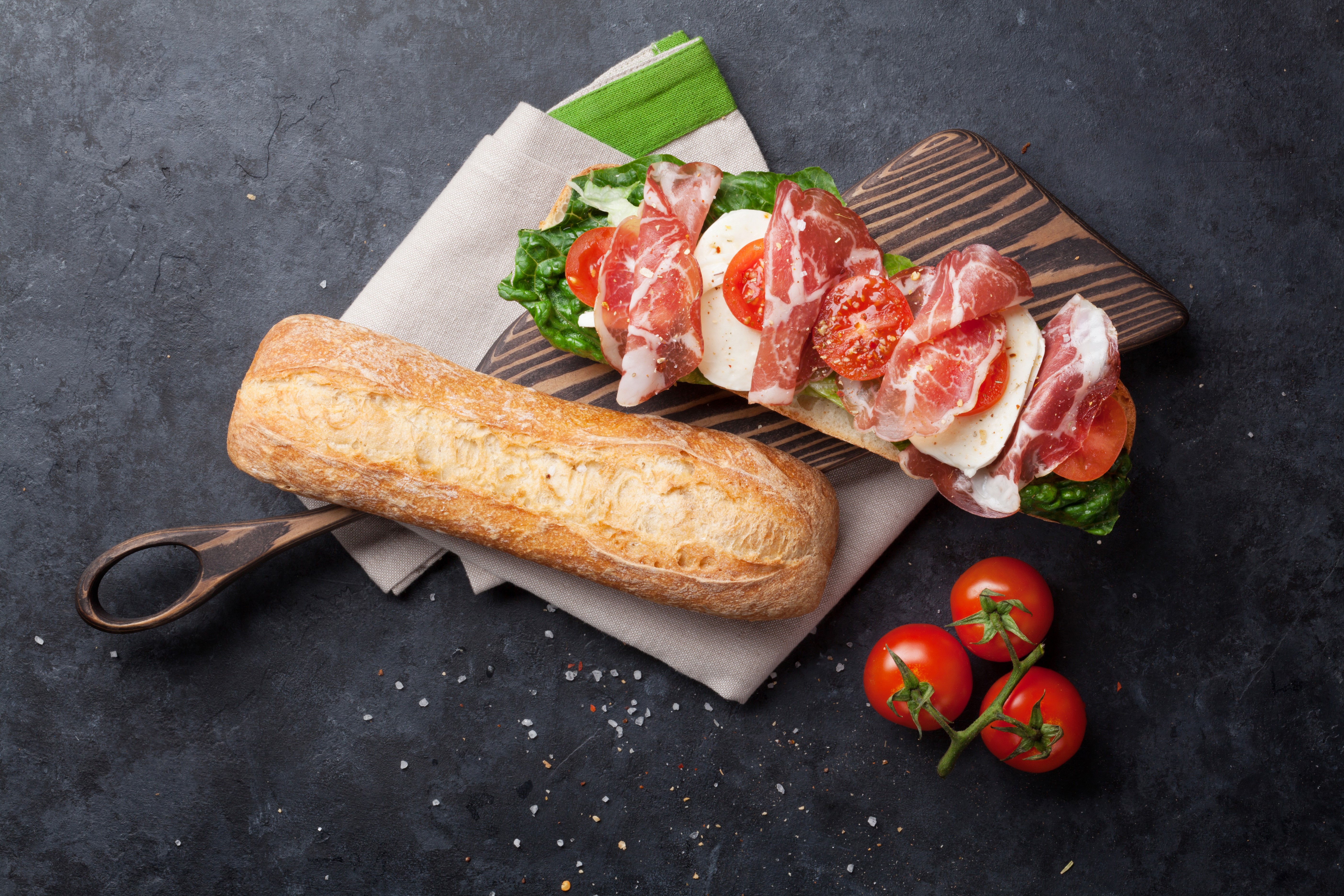 Sandwich with prosciutto, mozzarella, tomatoes, and lettuce on a baguette HD Wallpaper