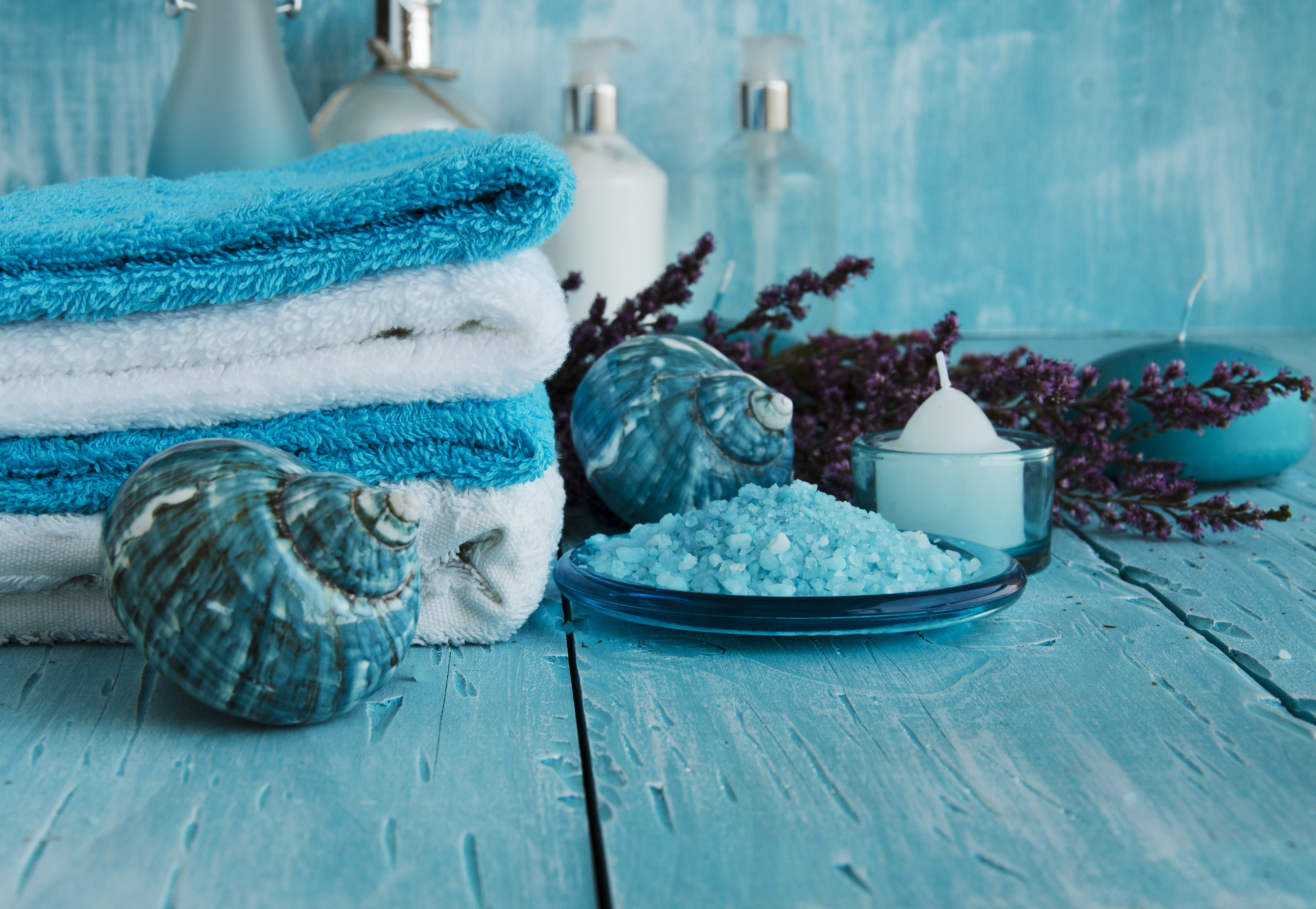 Spa towels, shells, salt, and candles on wood planks HD Wallpaper
