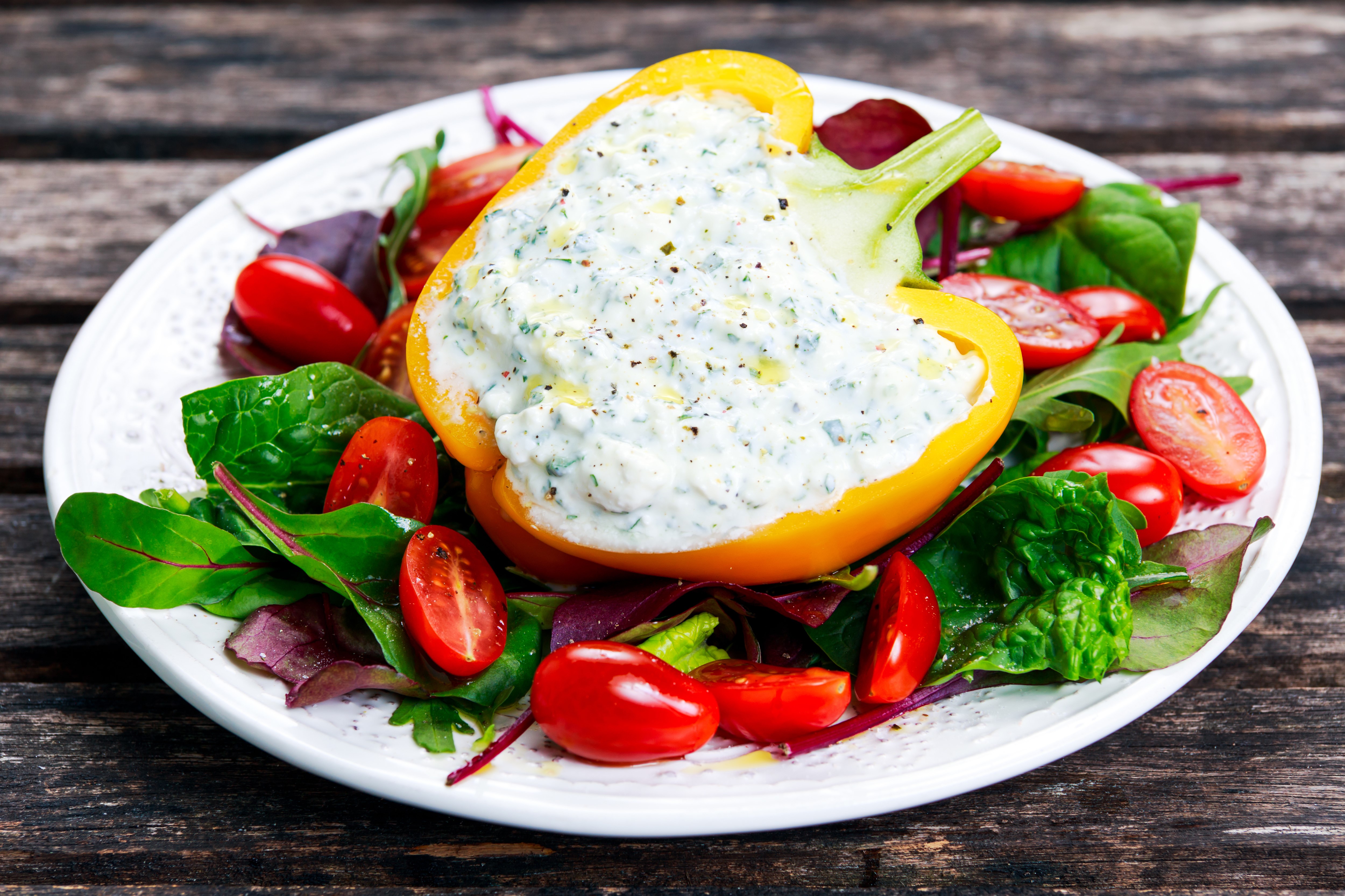 Stuffed yellow bell pepper with salad on a plate HD Wallpaper