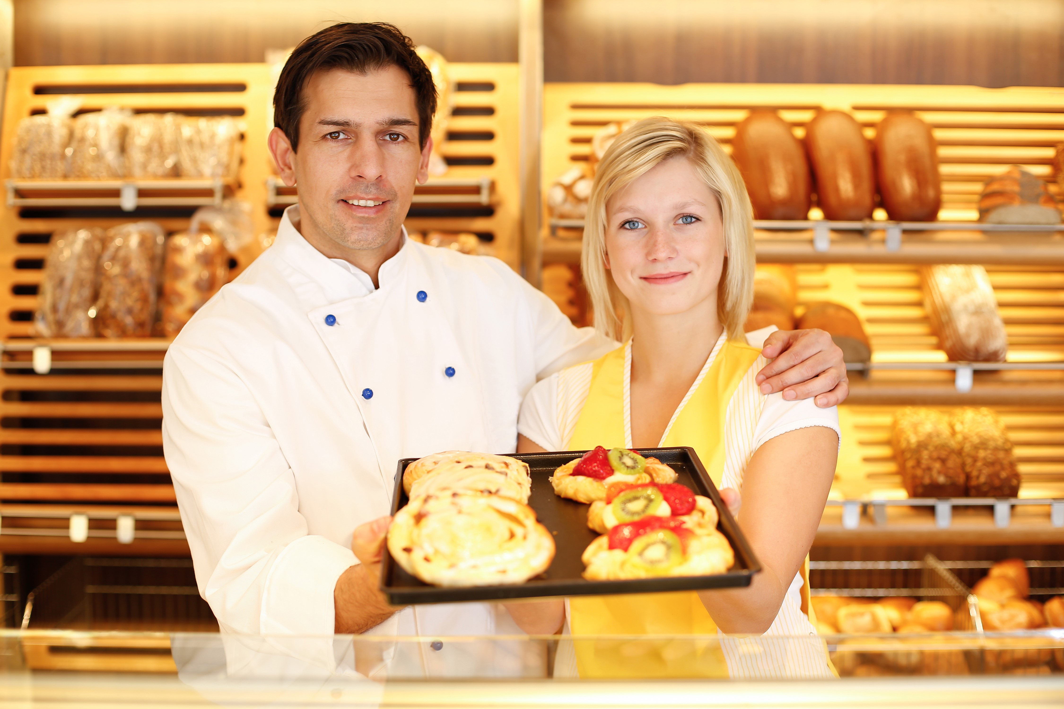 Two Bakers Holding Pastries in Bakery HD Wallpaper