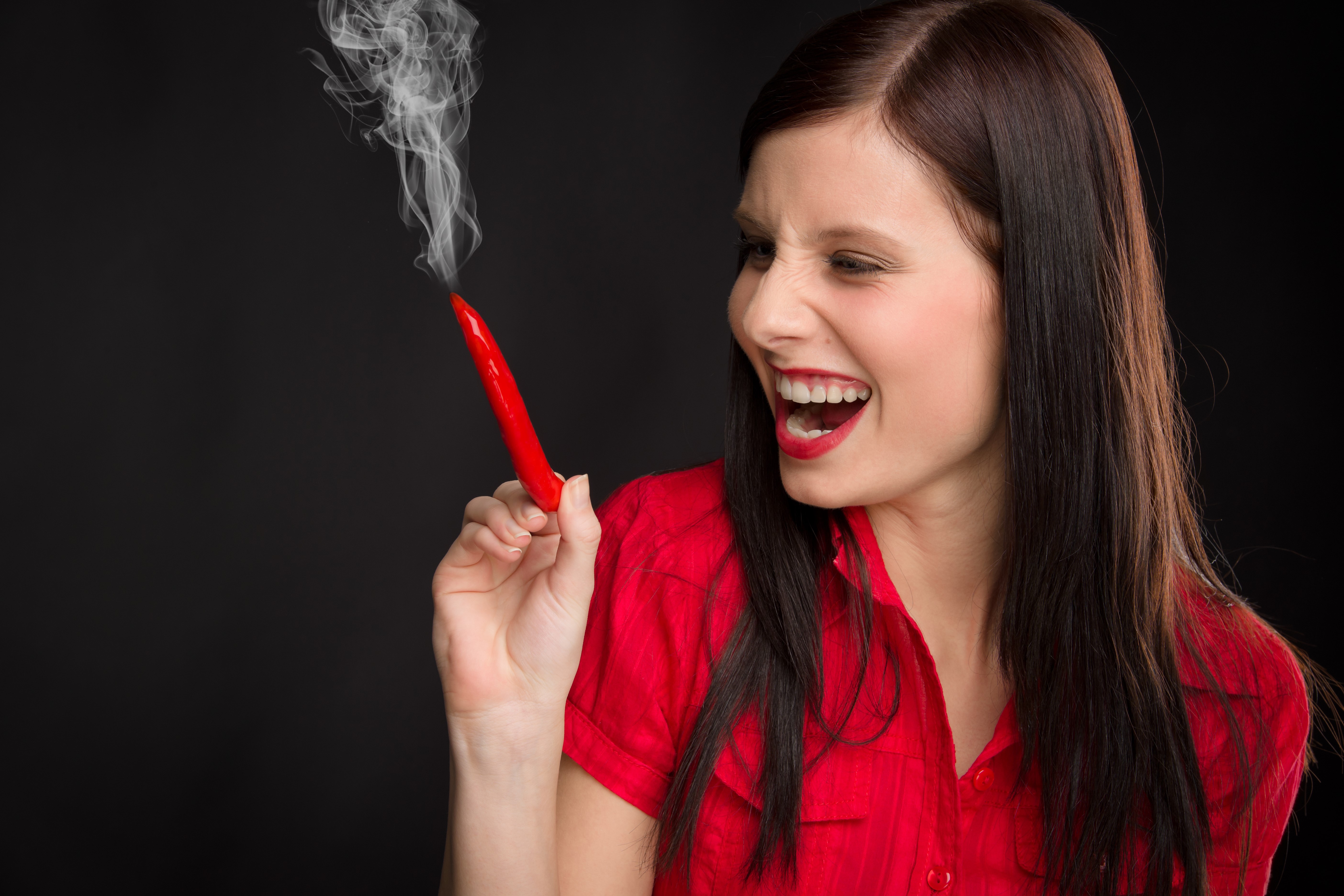 Woman laughing holding smoking chili pepper HD Wallpaper
