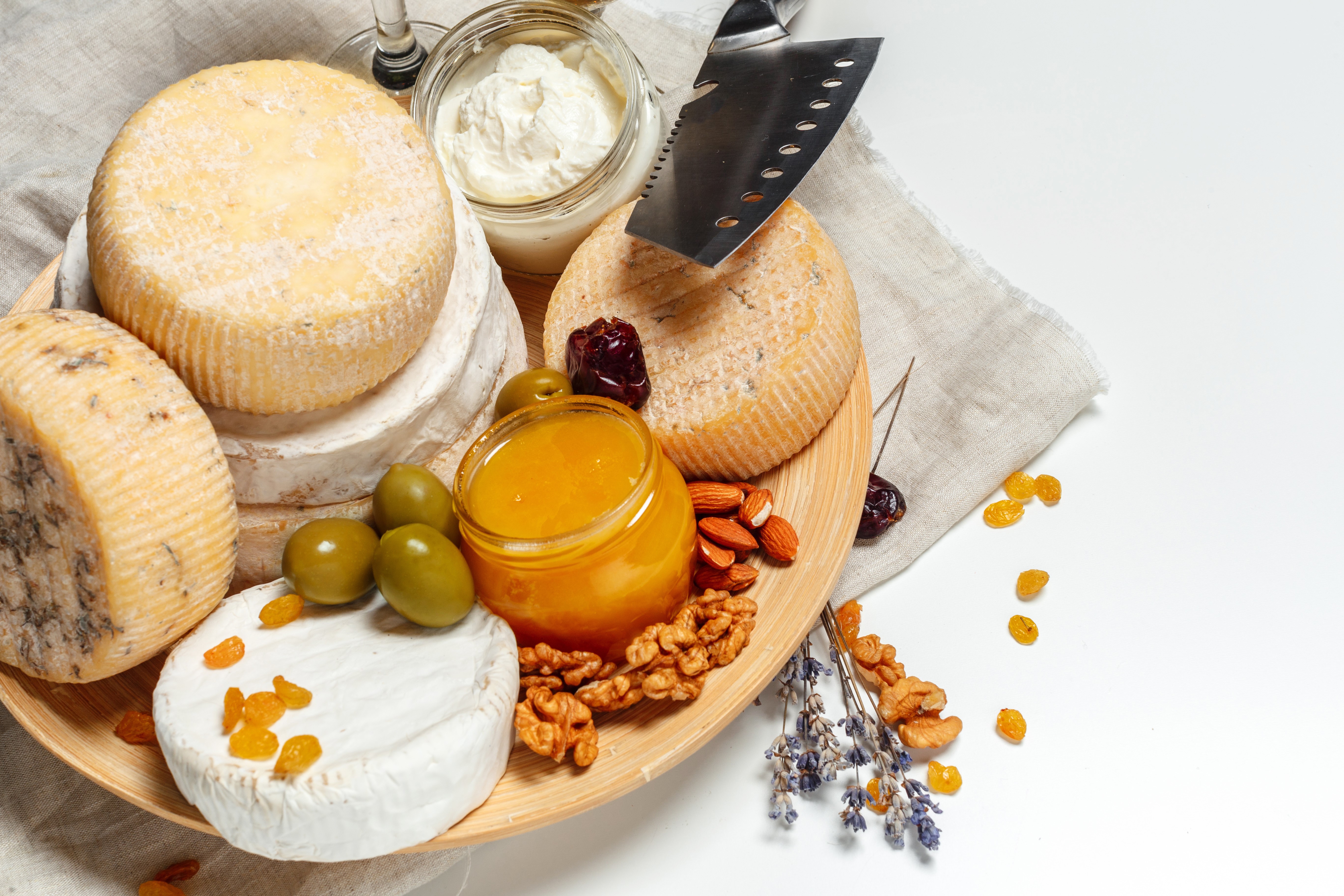 Cheese platter with honey, nuts, olives, and raisins HD Wallpaper
