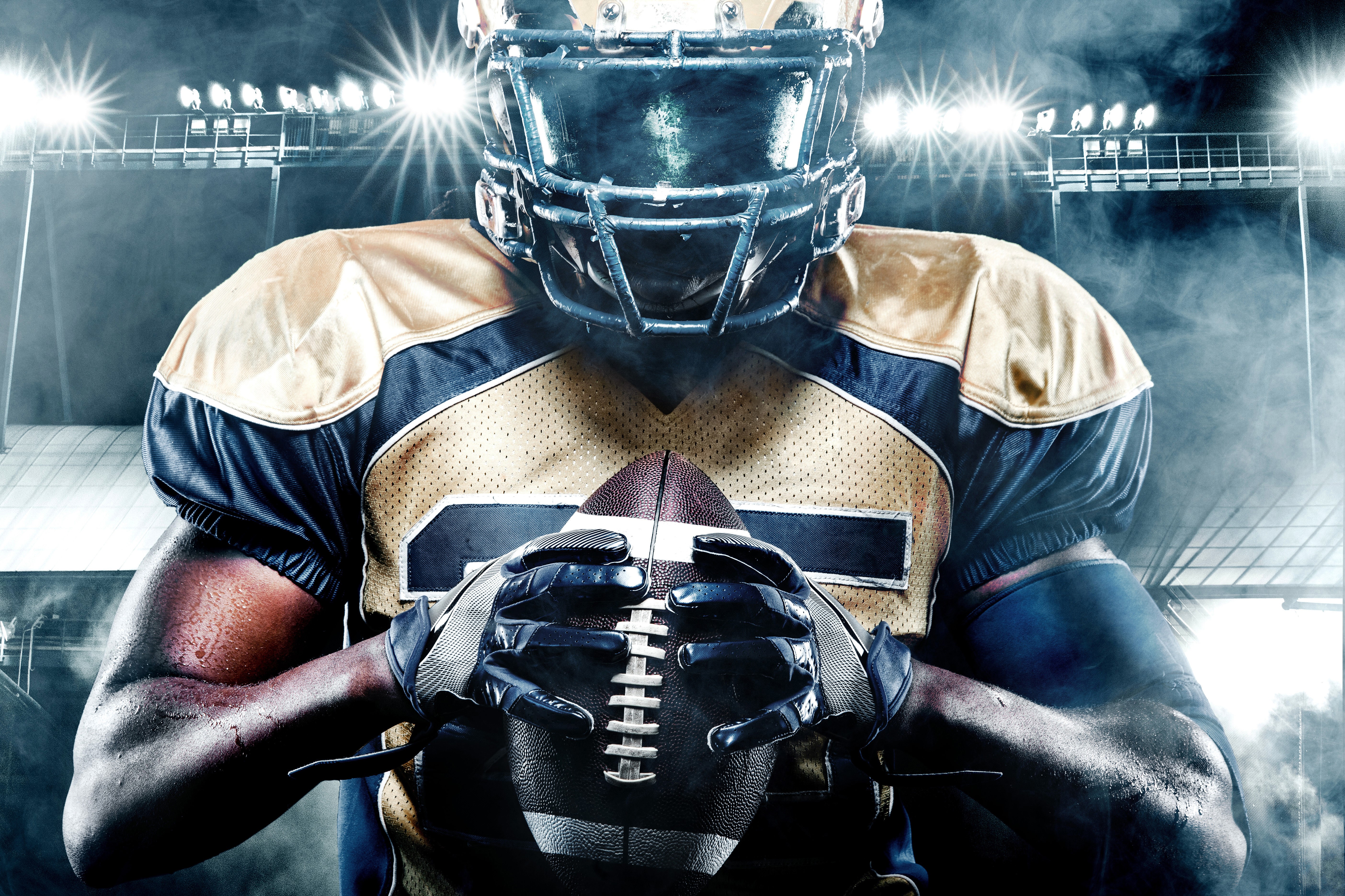 American football player holding a ball HD Wallpaper